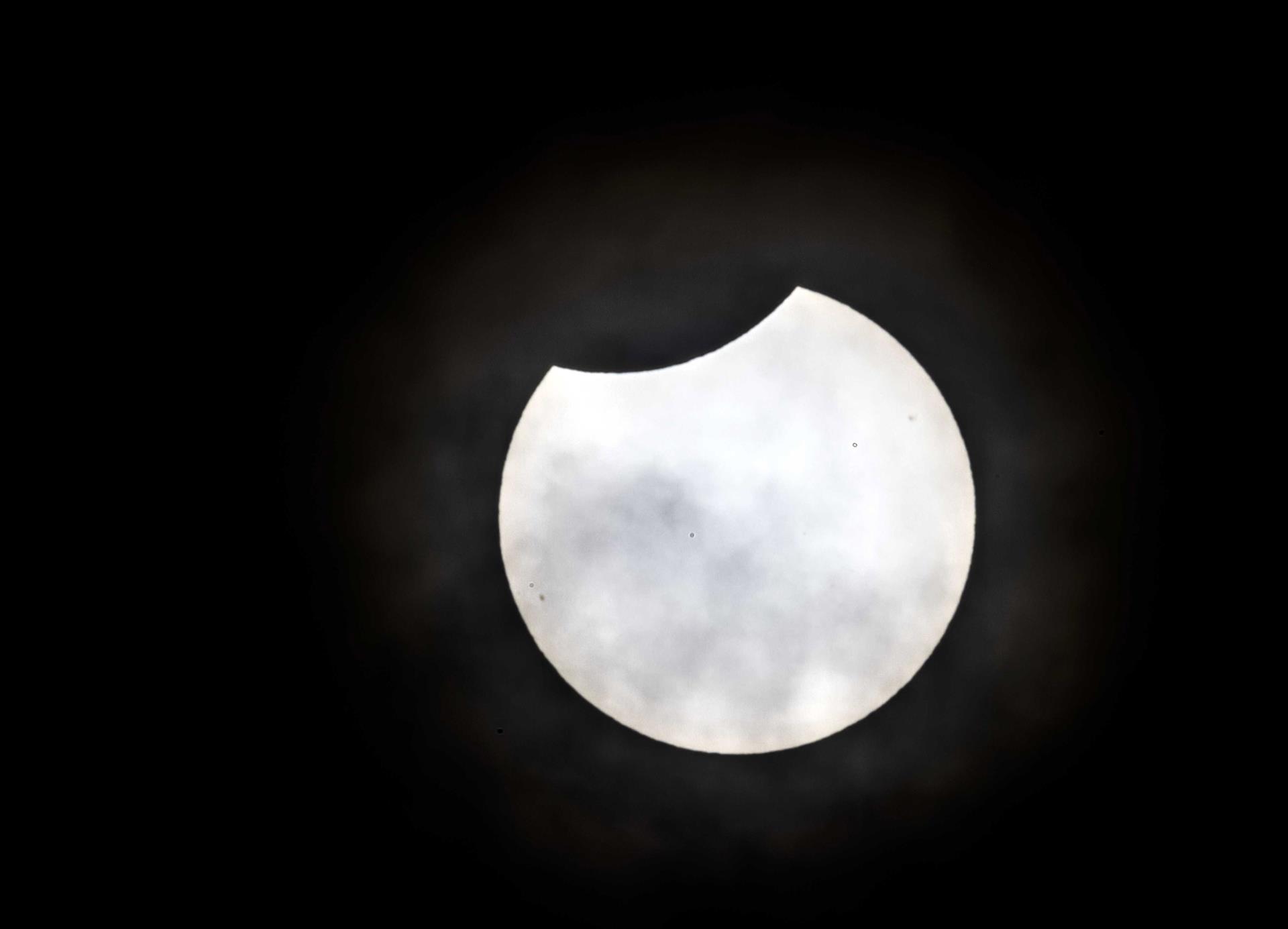 El sol se oculta parcialmente detrás de la luna, dando la impresión de que le está dando un mordisco (Países Bajos, Holanda).