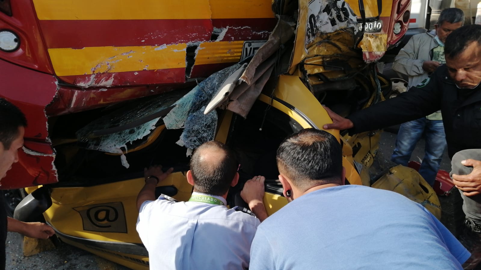 Taxi quedó atrapado debajo de un bus de Transmilenio tras accidente en Bogotá