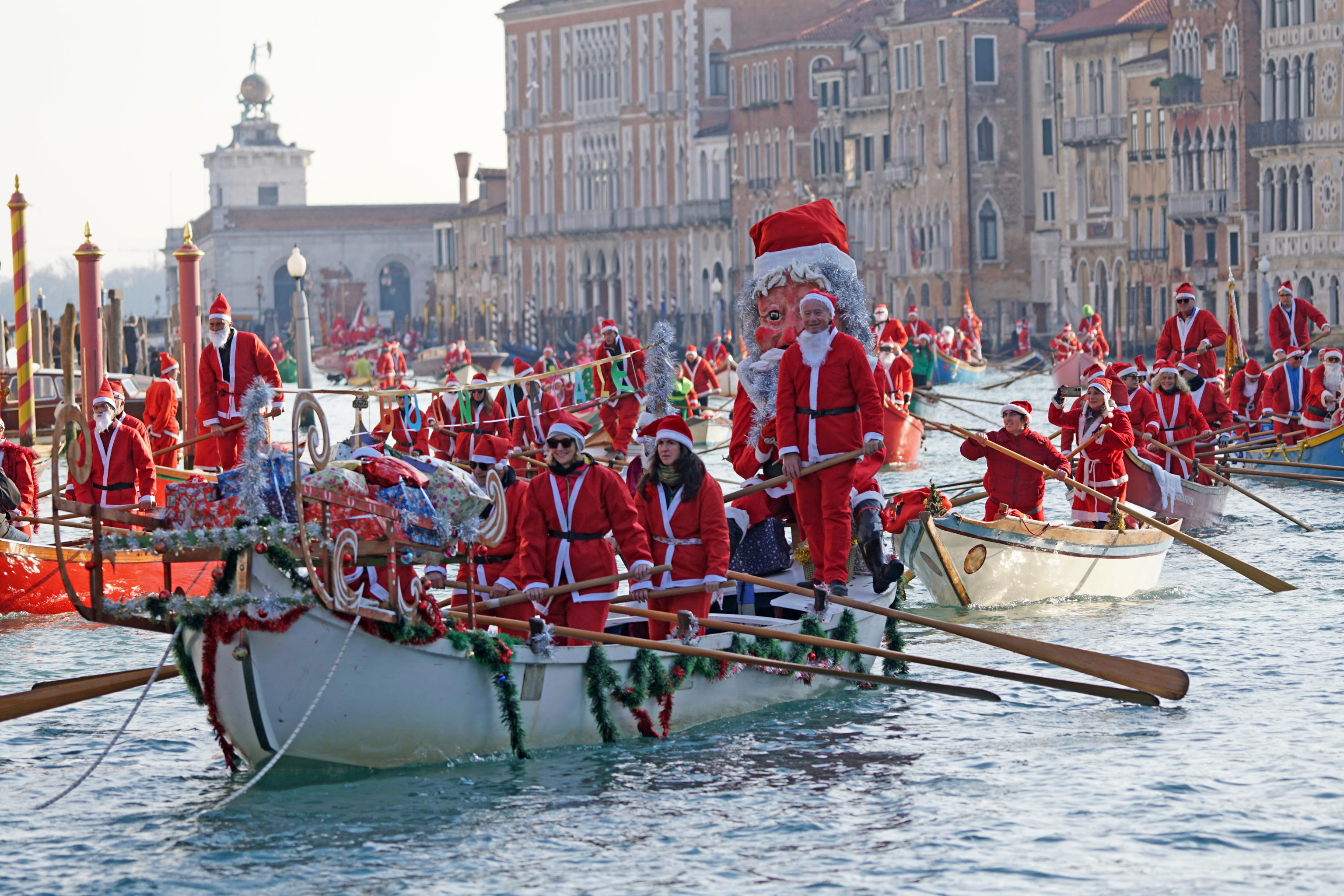 Venice (Italy), 22/12/2024.- People wearing Santa Claus costumes drive Gondolas on Canal Grande (The Grand Chanal) in Venice, Italy, 22 December 2024. Almost a hundred traditional rowing boats, of various kinds and sizes, for about two hundred rowers, men and women, gave life to the traditional water procession of the Santa Claus parading along the Grand Canal from the tip of the customs to Rialto. (Italia, Niza, Venecia) EFE/EPA/ANDREA MEROLA