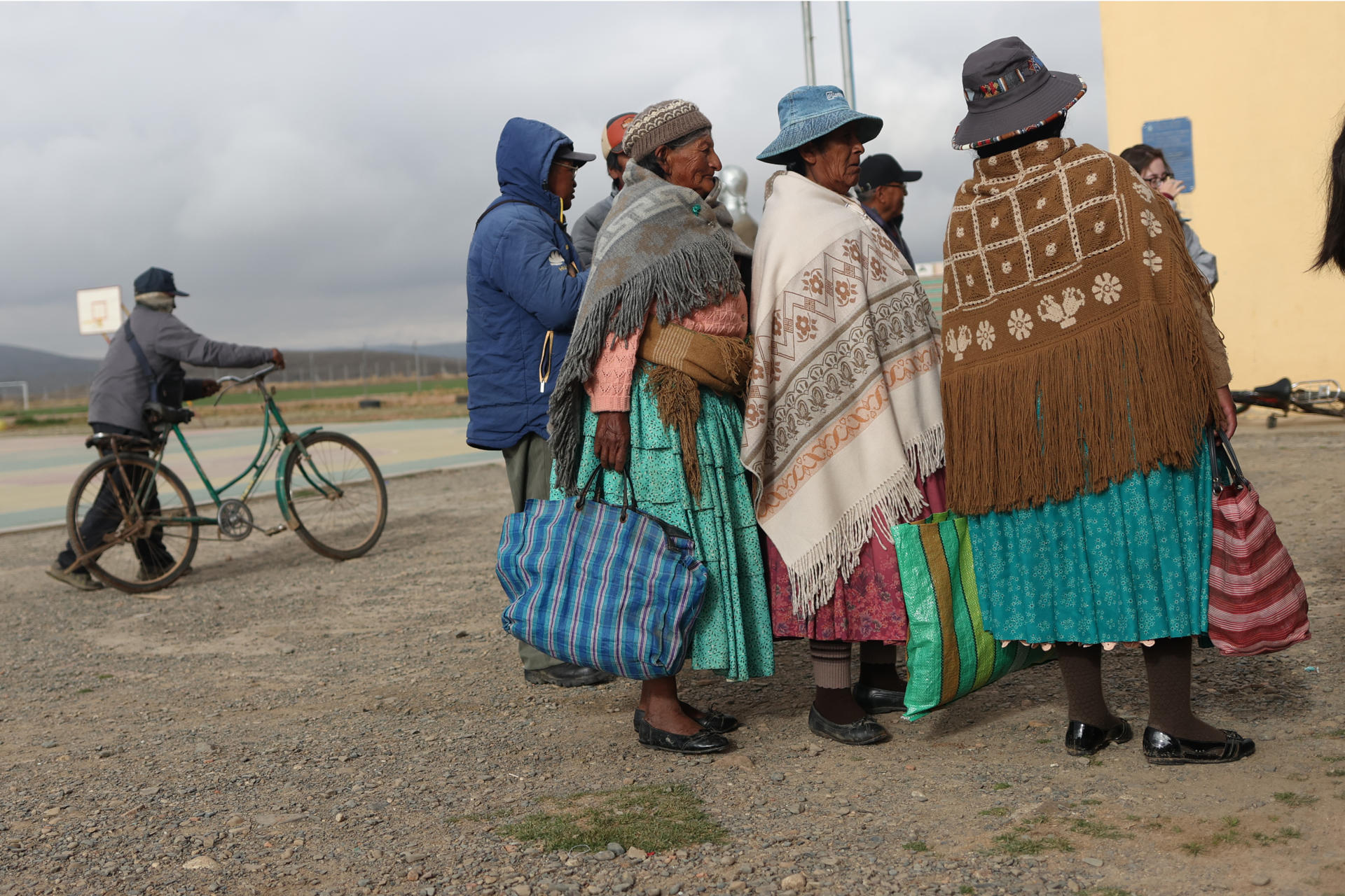 AME9620. LAJA (BOLIVIA), 19/10/2025.- Mujeres llegan a un centro votación este domingo, en la comunidad de Laja (Bolivia). Los pobladores de Laja en el altiplano de Bolivia, a 3.800 metros sobre el nivel del mar, acudieron a los colegios electorales cubiertos con frazadas desde temprano y bajo un cielo nublado para votar en la inédita segunda presidencial del país con la esperanza de que la crisis económica termine con el próximo gobierno. EFE/ Luis Gandarillas