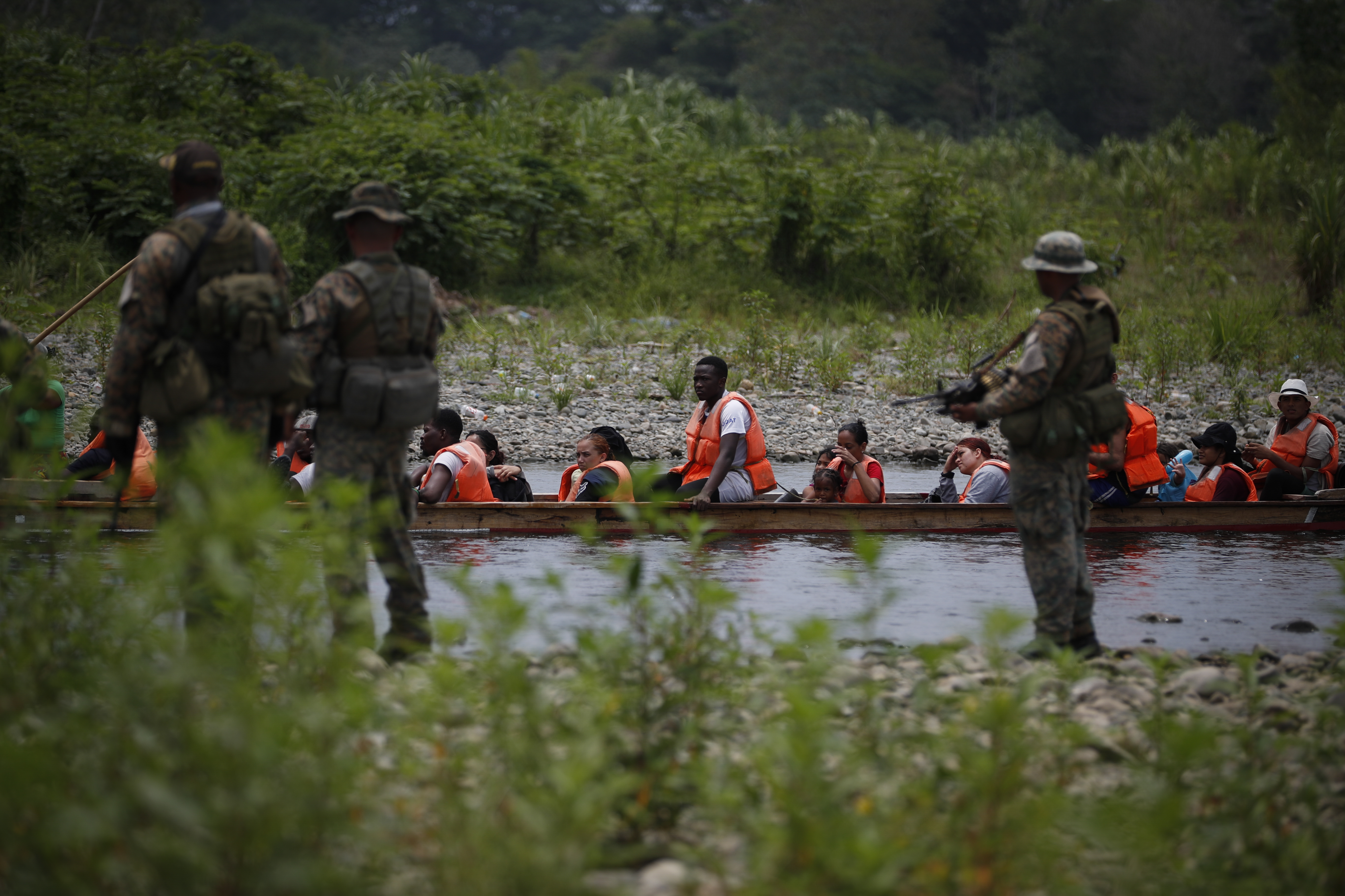 ACOMPAÑA CRÓNICA: CRISIS MIGRATORIA. AME5866. BAJO CHIQUITO (PANAMÁ), 15/05/2024.- Agentes del Servicio Nacional de Fronteras (SENAFRONT) custodian la llegada de migrantes luego de caminar por varios días la selva del Darién con rumbo a los Estados Unidos, el 9 de abril de 2024, en Bajo Chiquito (Panamá). Para el colectivo LGTBIQ+ la ruta migratoria hacia Estados Unidos no solo significa huir de la pobreza para intentar mejorar la economía familiar, sino también la búsqueda de la libertad de mostrarse como son, sin tener que esconderse por los ataques, la persecución y burlas en sus países de origen. EFE/ Bienvenido Velasco