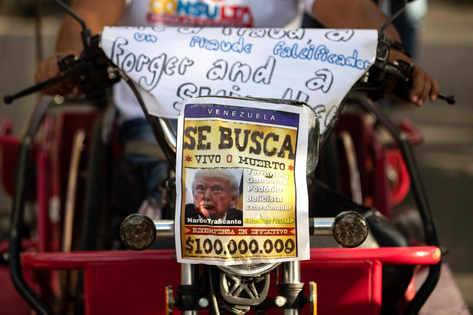 AME102. CARACAS (VENEZUELA), 22/12/2025.- Fotografía que muestra un cartel con la imagen del presidente de los Estados Unidos, Donald Trump, durante una caravana de motociclistas este lunes, en Caracas (Venezuela). Cientos de motoristas simpatizantes del chavismo, algunos disfrazados de piratas, recorrieron varias zonas de Caracas en protesta por la confiscación de dos buques con petróleo venezolano por parte de Estados Unidos y exhibieron afiches con la imagen del presidente Donald Trump con sombrero y parche. EFE/ Ronald Pena R
