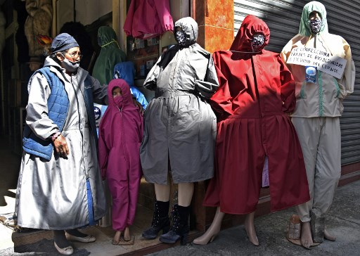 Una mujer boliviana vende en la paz tapabocas y material de protección contra el coronavirus.