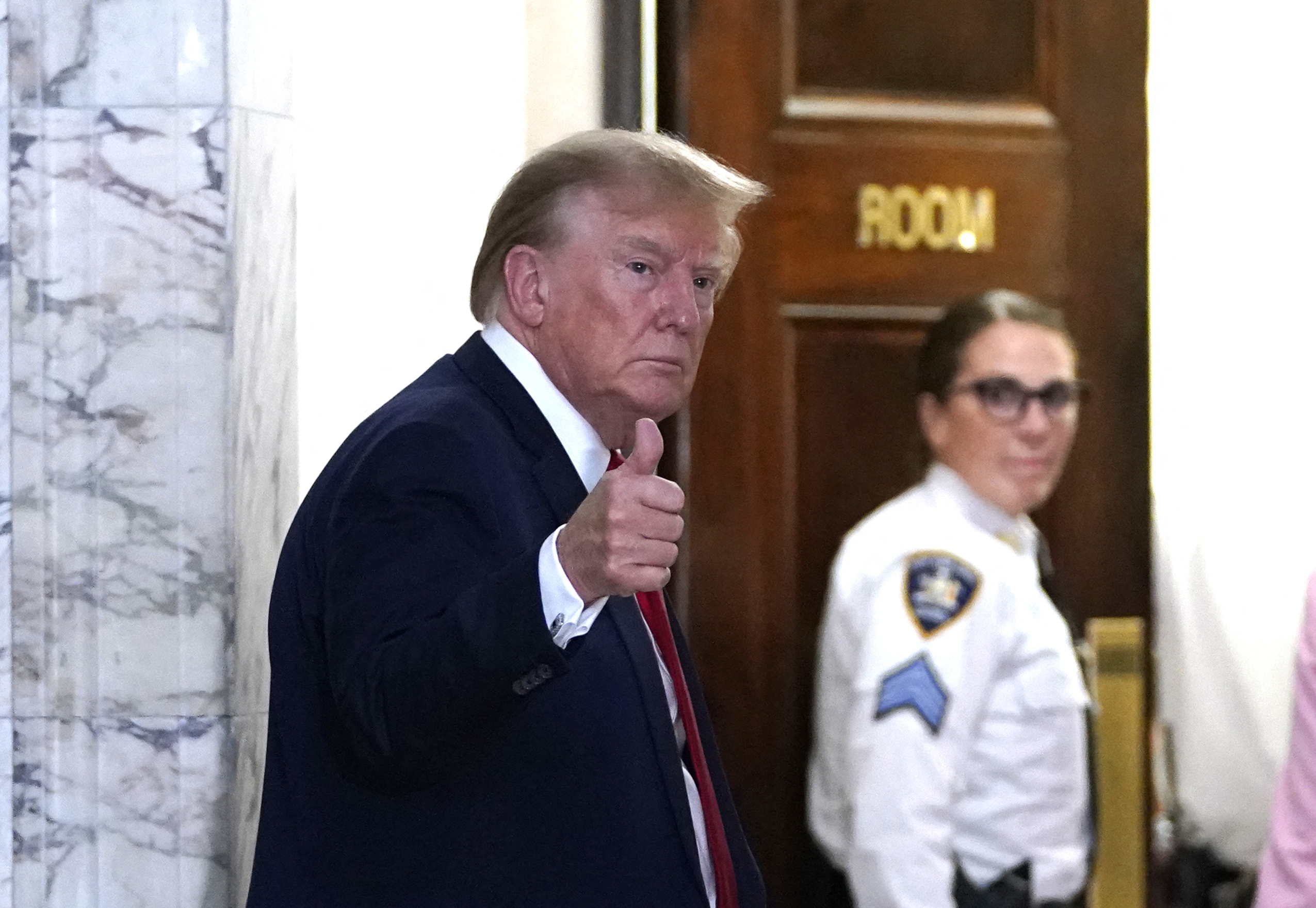 Former US President Donald Trump gestures as he returns from a break  at the New York State Supreme Court during the civil fraud trial against the Trump Organization, in New York City on December 7, 2023. Former US president Donald Trump was back in court on December 7, 2023, for his New York civil trial on fraud allegations, once again condemning the process as unfair. Trump, the frontrunner for the 2024 Republican presidential nomination, and his two eldest sons are accused of inflating the value of their real estate assets to receive more favorable bank loans and insurance terms. (Photo by TIMOTHY A. CLARY / AFP)