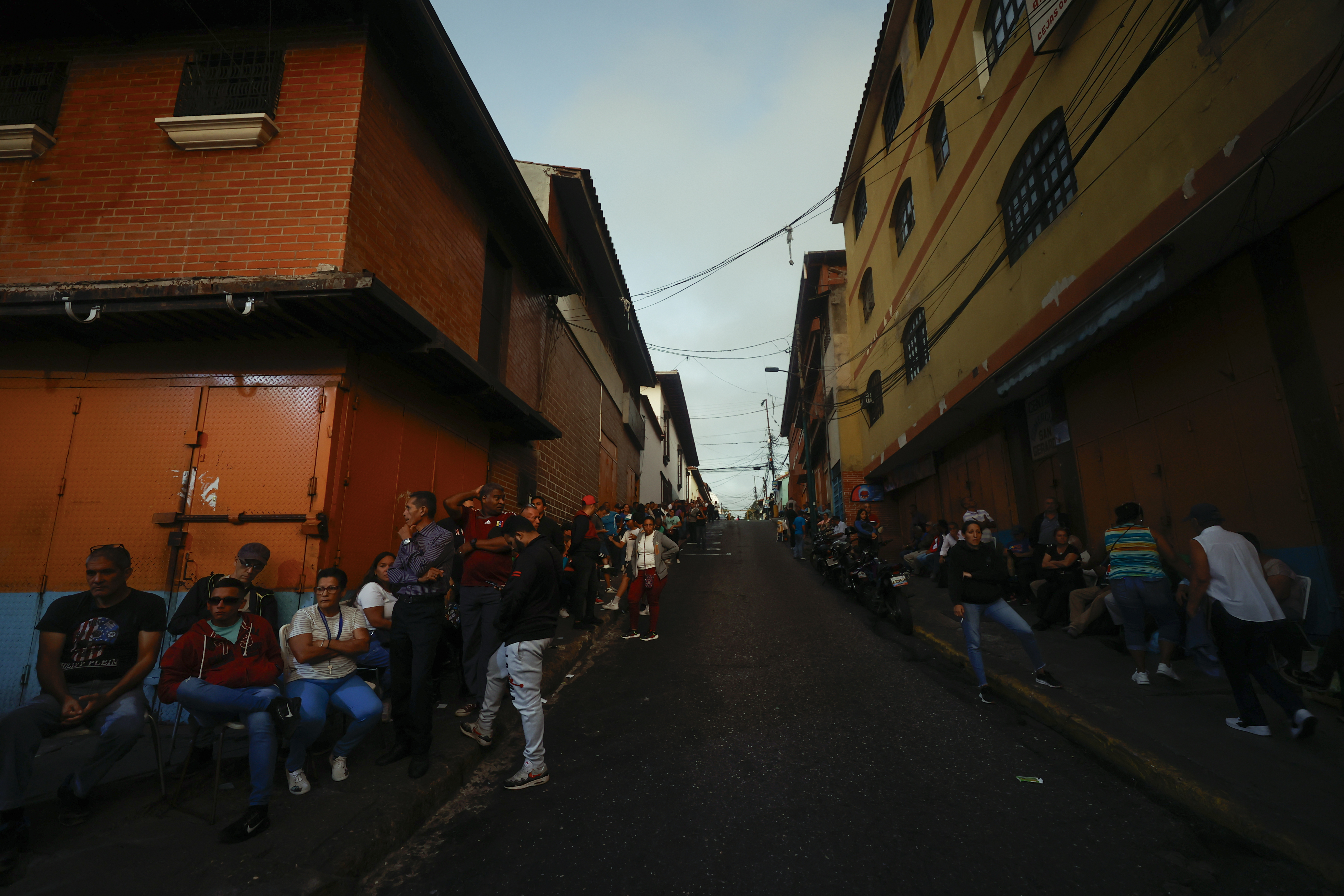 AME5489. CARACAS (VENEZUELA), 28/07/2024.- Ciudadanos esperan para votar este domingo, afuera de un centro de votación en Caracas (Venezuela). Los centros electorales de Venezuela comenzaron a abrir sus puertas pasadas las 06.00 hora local (10.00 GMT) de este domingo y empezaron a recibir a los votantes que participan en la elección presidencial, una jornada para la que están llamadas a las urnas más de 21 millones de personas. EFE/ Henry Chirinos