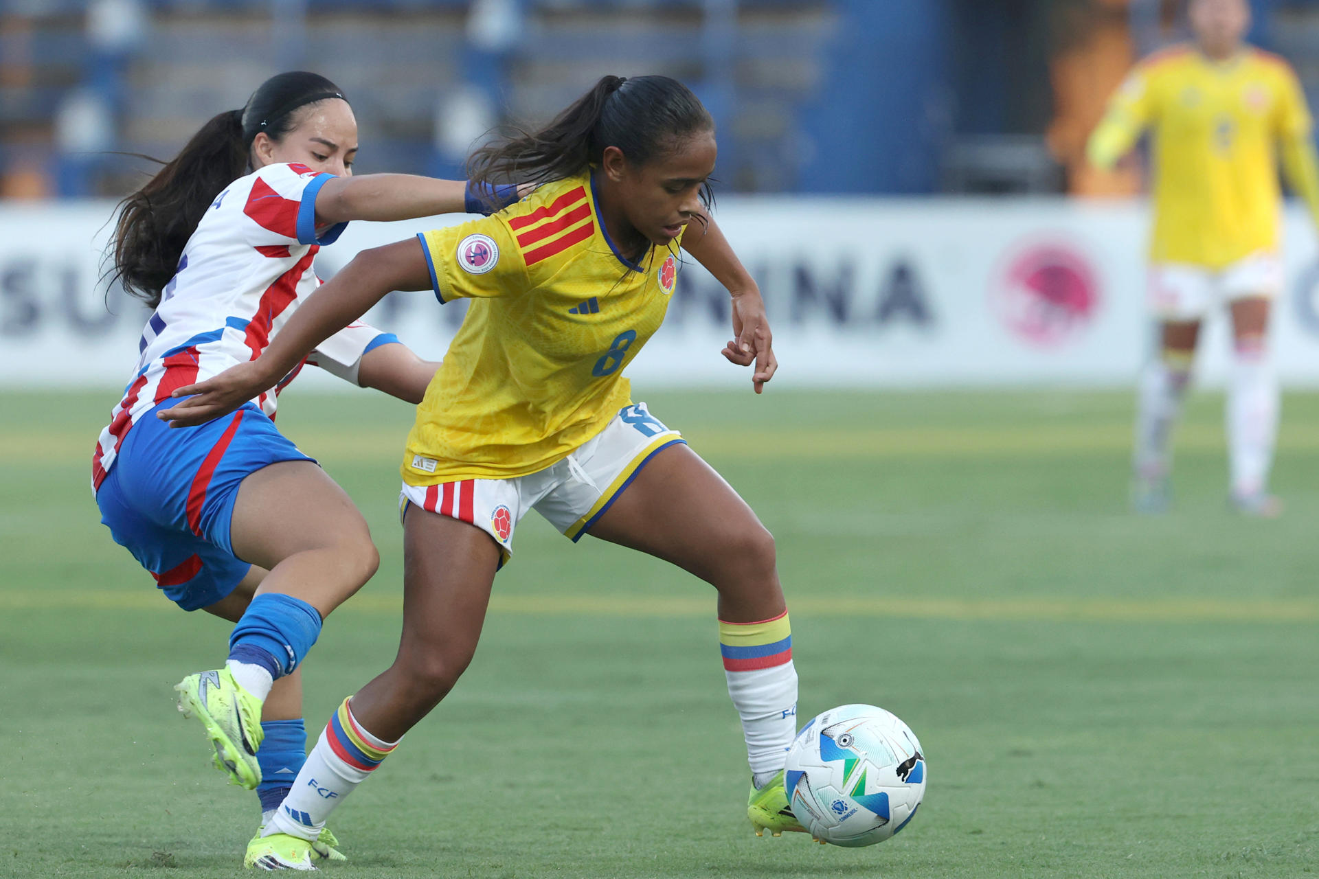 AME4476. VILLA ELISA (PARAGUAY), 12/02/2026.- Pamela Villalba (i) de Paraguay disputa un balón con Mariana Mosquera de Colombia este jueves, en un partido del Sudamericano Femenino Sub-20 entre Paraguay y Colombia en el estadio Luis Alfonso Giagni en Villa Elisa (Paraguay). EFE/ Juan Pablo Pino