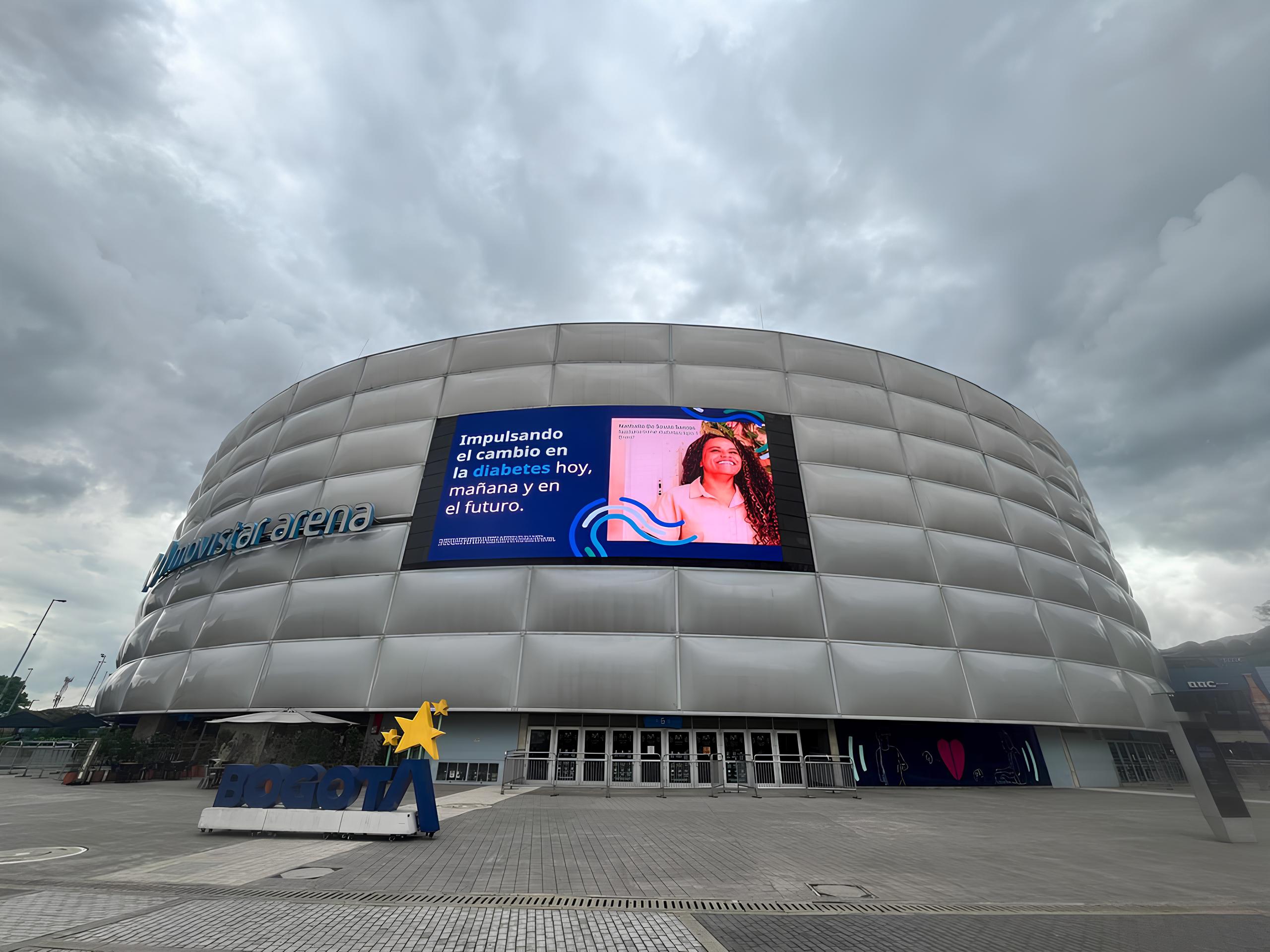 El Movistar Arena, brillando en tono azul, se erige como un símbolo de solidaridad y esperanza.