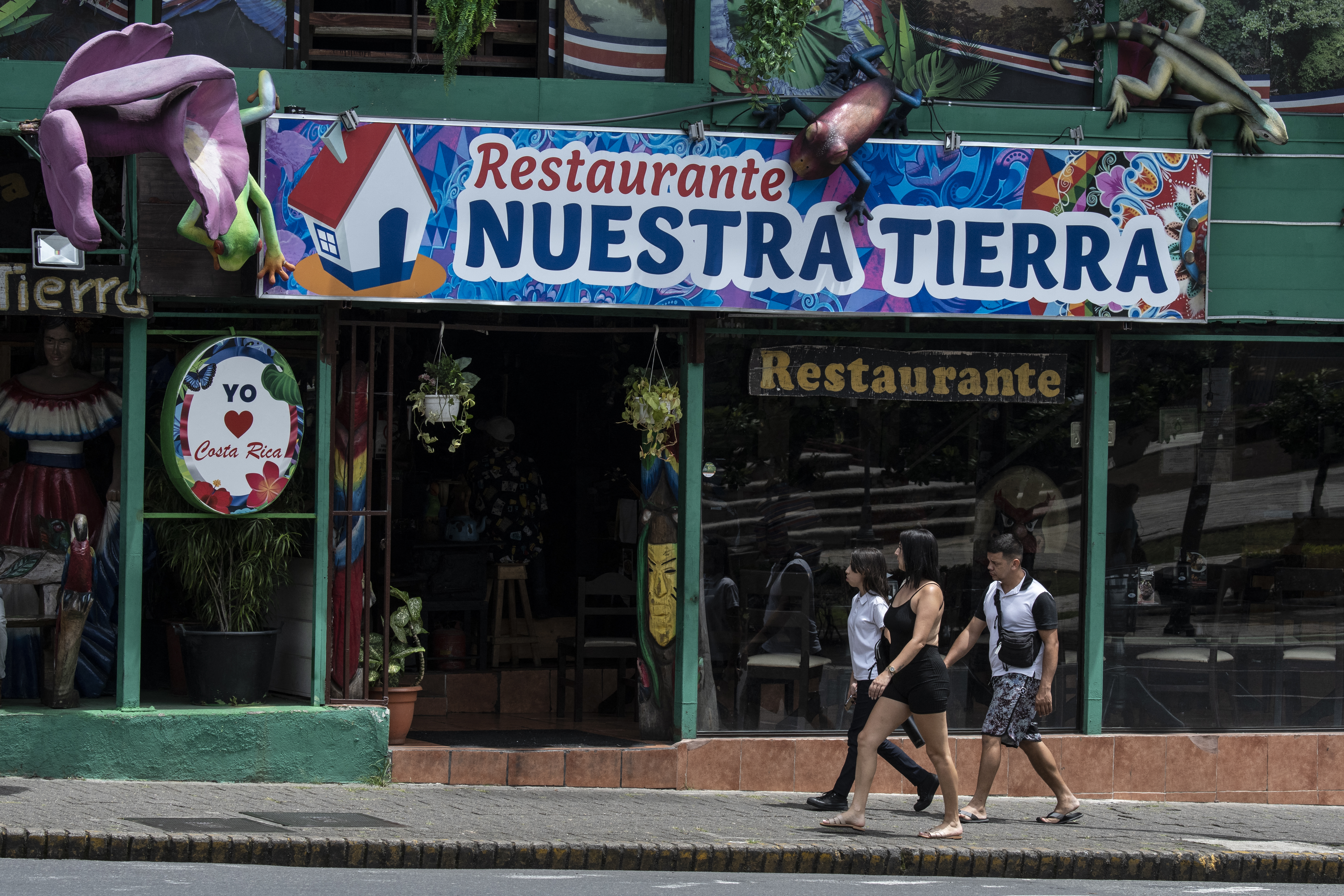 Tourists walk in front of a typical food restaurant in San Jose, on July 18, 2024.