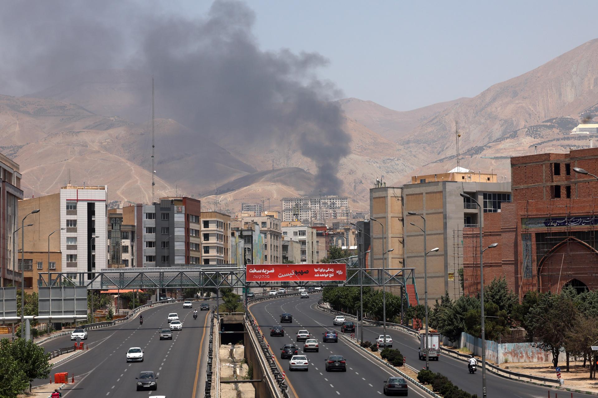 TEHRAN (IRAN(Islamic Republic Of)), 16/06/2025.- Cars drive along a motorway as smoke rises in the background from an oil refinery, northwest of Tehran, Iran, 16 June 2025. Israel and Iran have been exchanging fire since Israel launched strikes across Iran on 13 June 2025 as part of Operation 'Rising Lion.' (Teherán) EFE/EPA/ABEDIN TAHERKENAREH