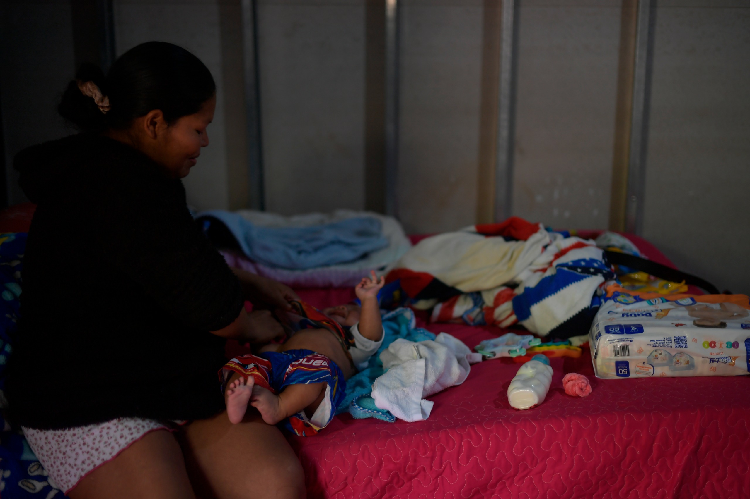 Ana viste a su hijo menor en su casa del antiguo ETCR Antonio Nariño en Icononzo, Tolima.
