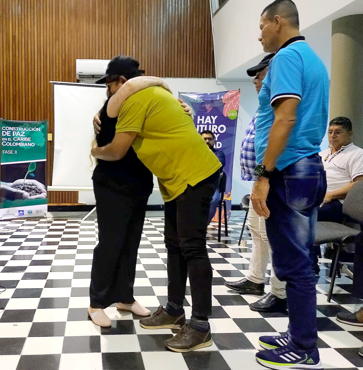 Abrazo entre asistentes del evento “Mesa de combatientes, de la guerra a la paz de los Montes de María” en Cartagena.
