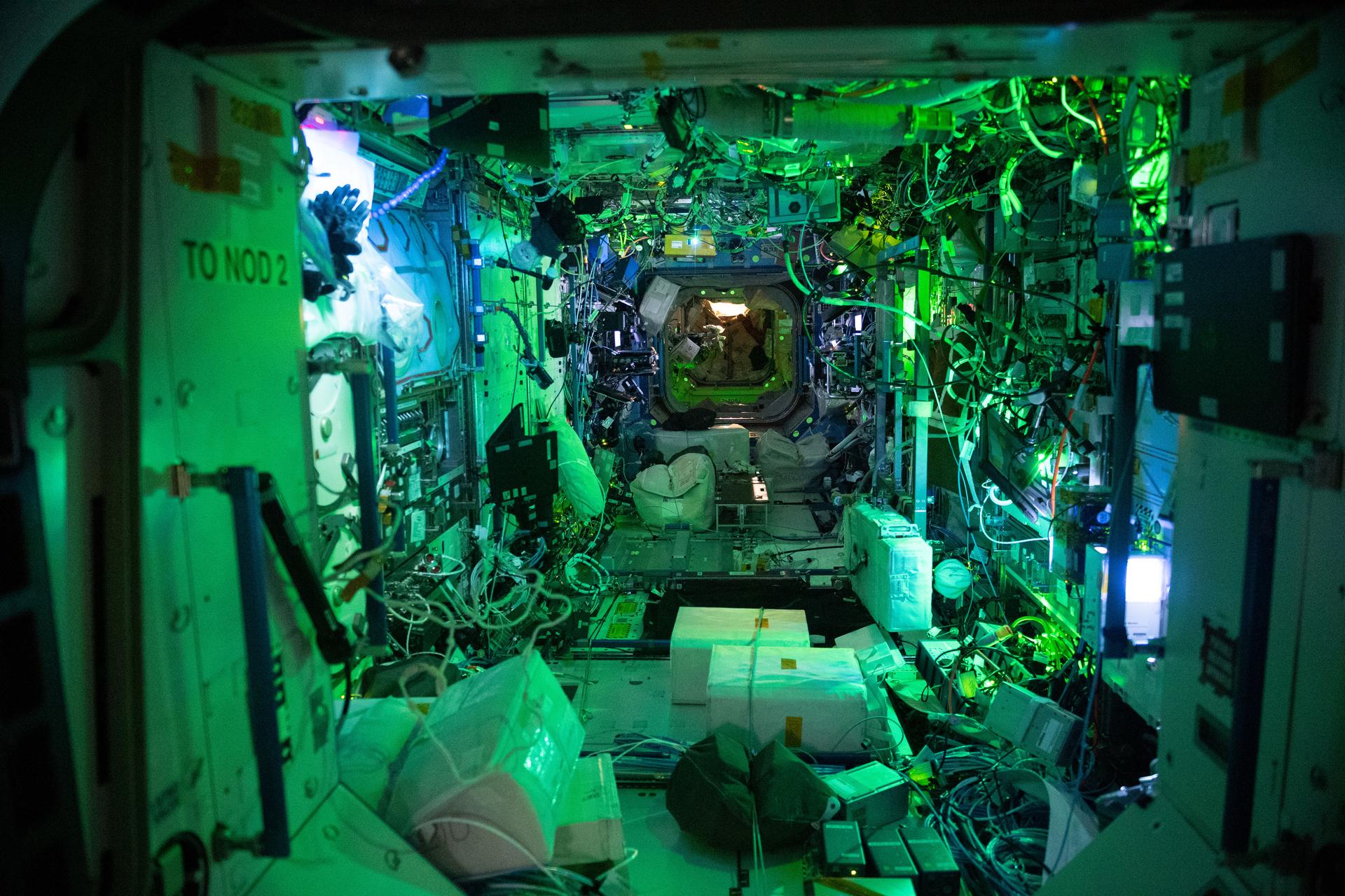 Una vista interior del Laboratorio Destiny de noche bajo luz ambiental con las luces principales apagadas. /NASA