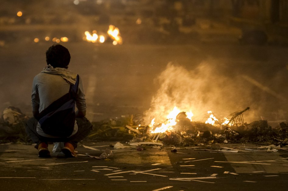 Un hombre permanece junto al fuego de las barricadas durante las protestas contra el Gobierno del presidente venezolano