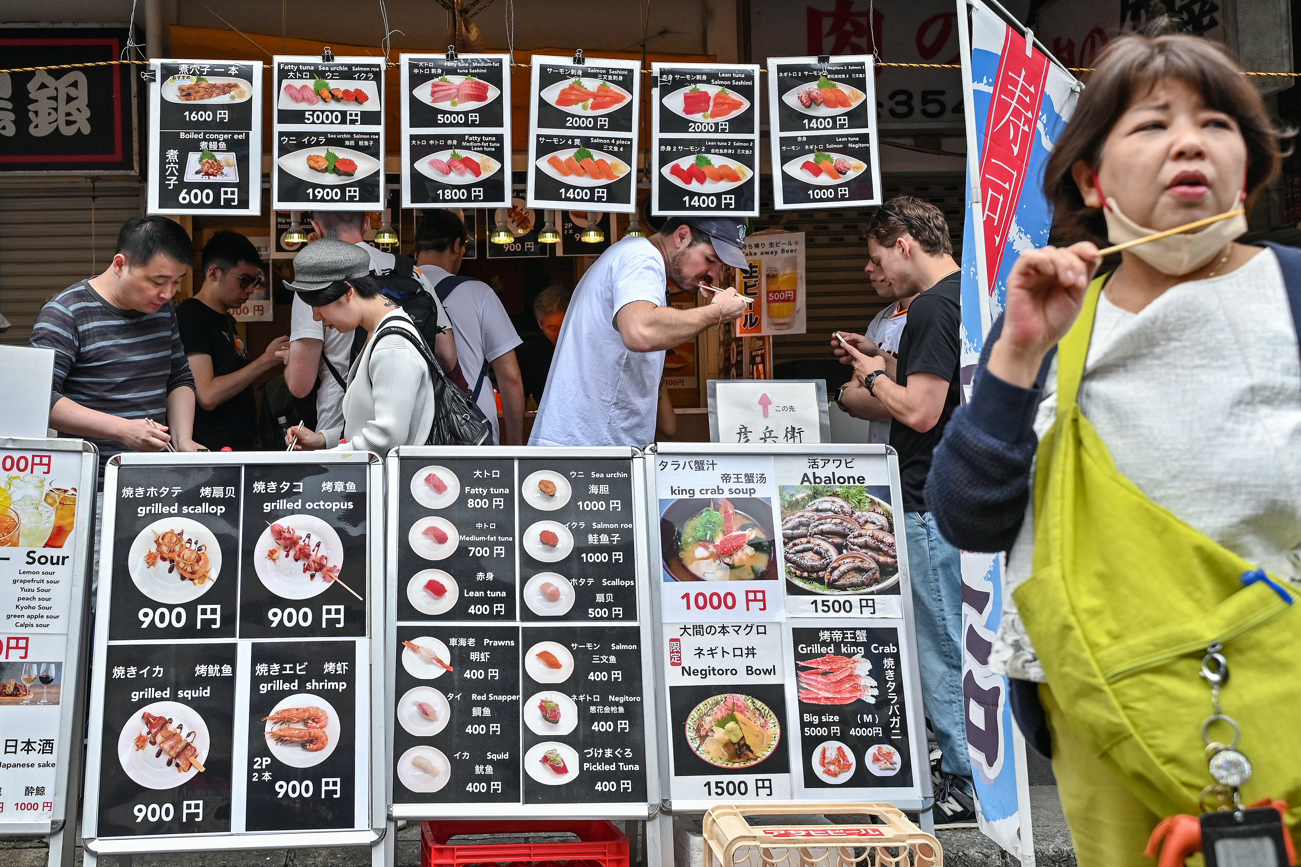 Visitors eat seafood during lunchtime at the popular tourist area of Tsukiji fish market in central Tokyo as the country marks the "Golden Week" holidays on April 30, 2024.