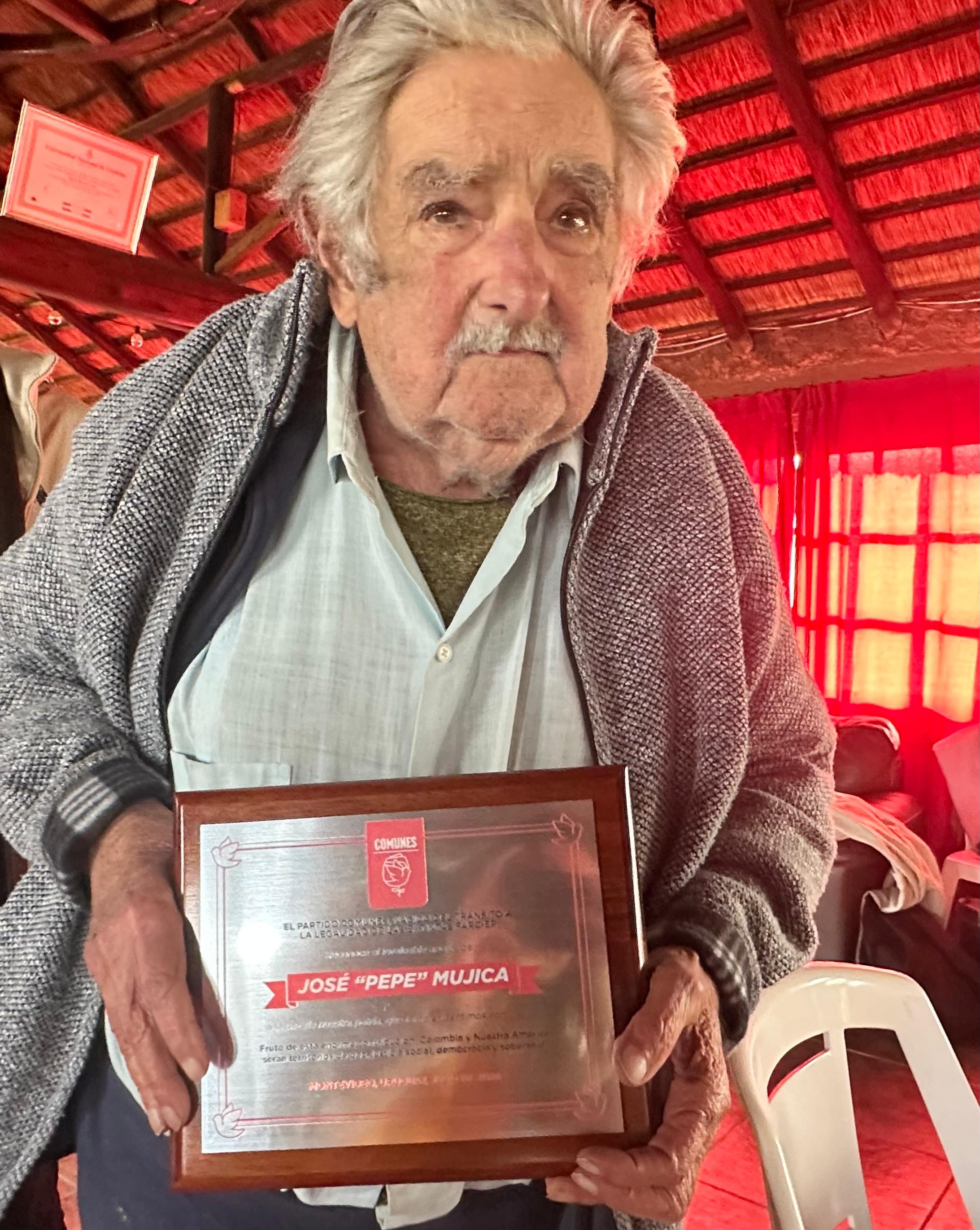 Mujica recibiendo la placa de reconocimiento por parte del partido Comunes.