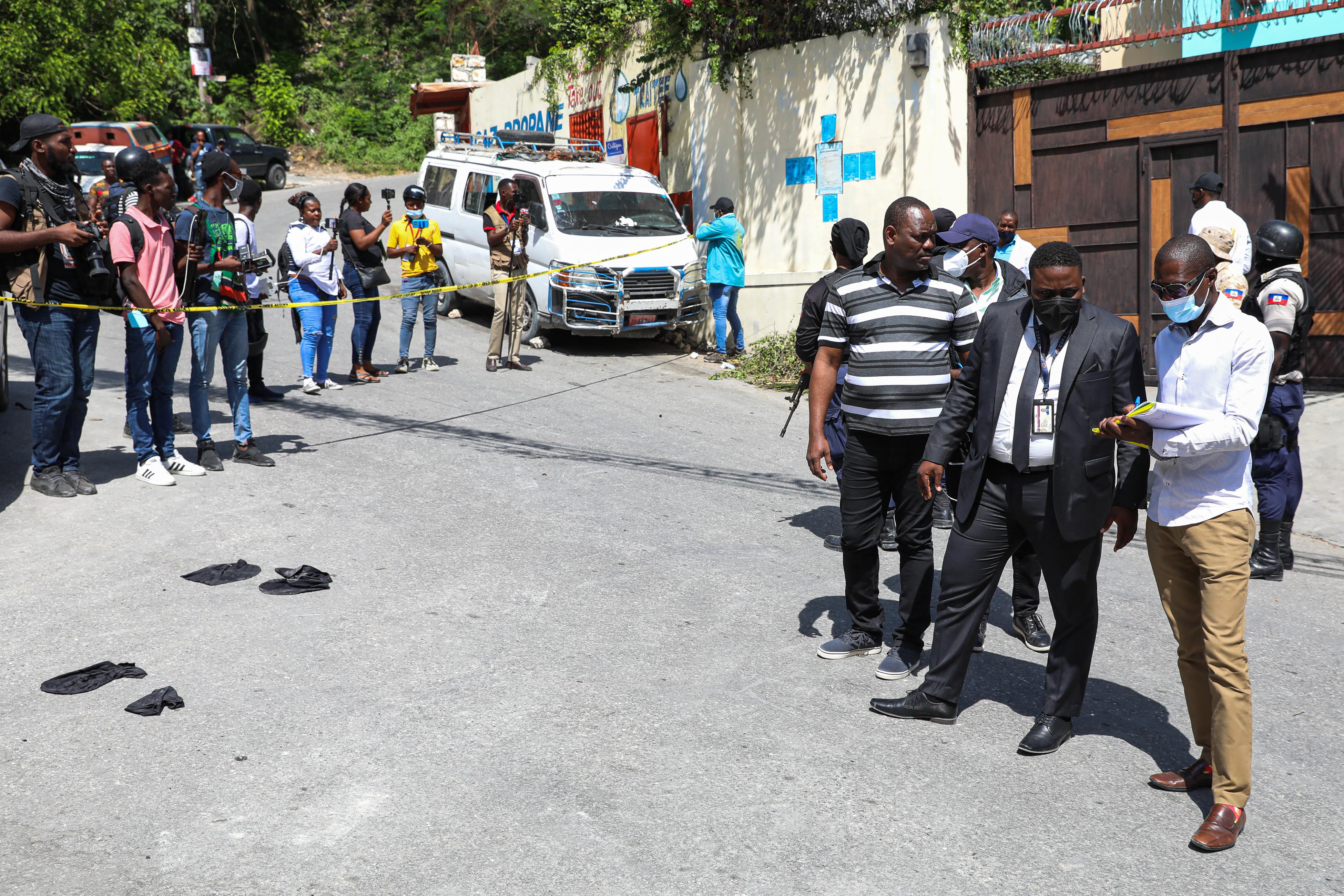 El juez Carl Henry Celestin (2R) junto con la Direction Centrale de la Police Judiciaire (DCPJ) y el equipo de forenses, patrullan el área fuera de la residencia presidencial el 7 de julio de 2021 en Puerto Príncipe, Haití.
