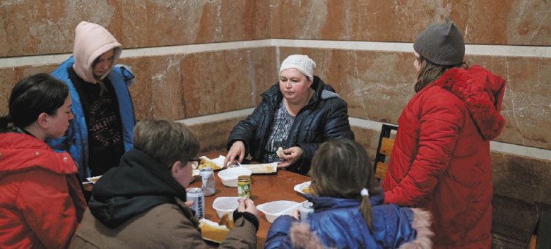 Una familia llegada desde Kiev se alimenta gracias a las raciones distribuidas por voluntarios en la estación de trenes de Uzhgorod.
