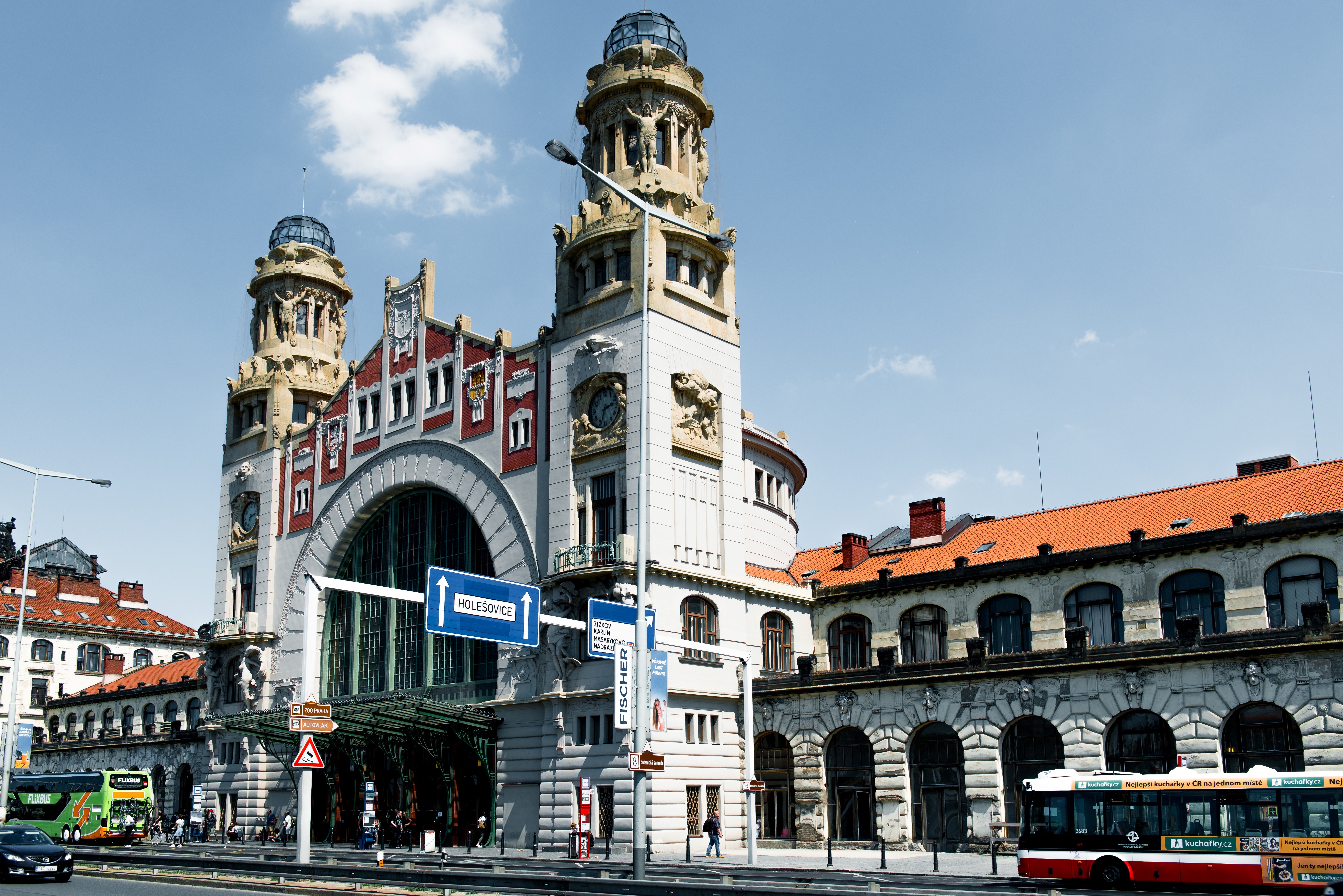 La Prague Main Railway Station, conocida como Hlavní Nádraží, es la mayor estación de la ciudad y un punto clave del transporte, pero también un lugar cargado de historia y contraste arquitectónico. Su antiguo edificio, inaugurado en 1871 y transformado entre 1901 y 1909 por Josef Fanta, destaca por su elegante cúpula y ricos detalles art nouveau, hoy parcialmente ocultos tras ampliaciones más modernas de estilo brutalista. Además, en su interior alberga un emotivo monumento a Nicholas Winton, quien salvó a cientos de niños judíos durante la Segunda Guerra Mundial, lo que refuerza su valor no solo como estación, sino como espacio de memoria.