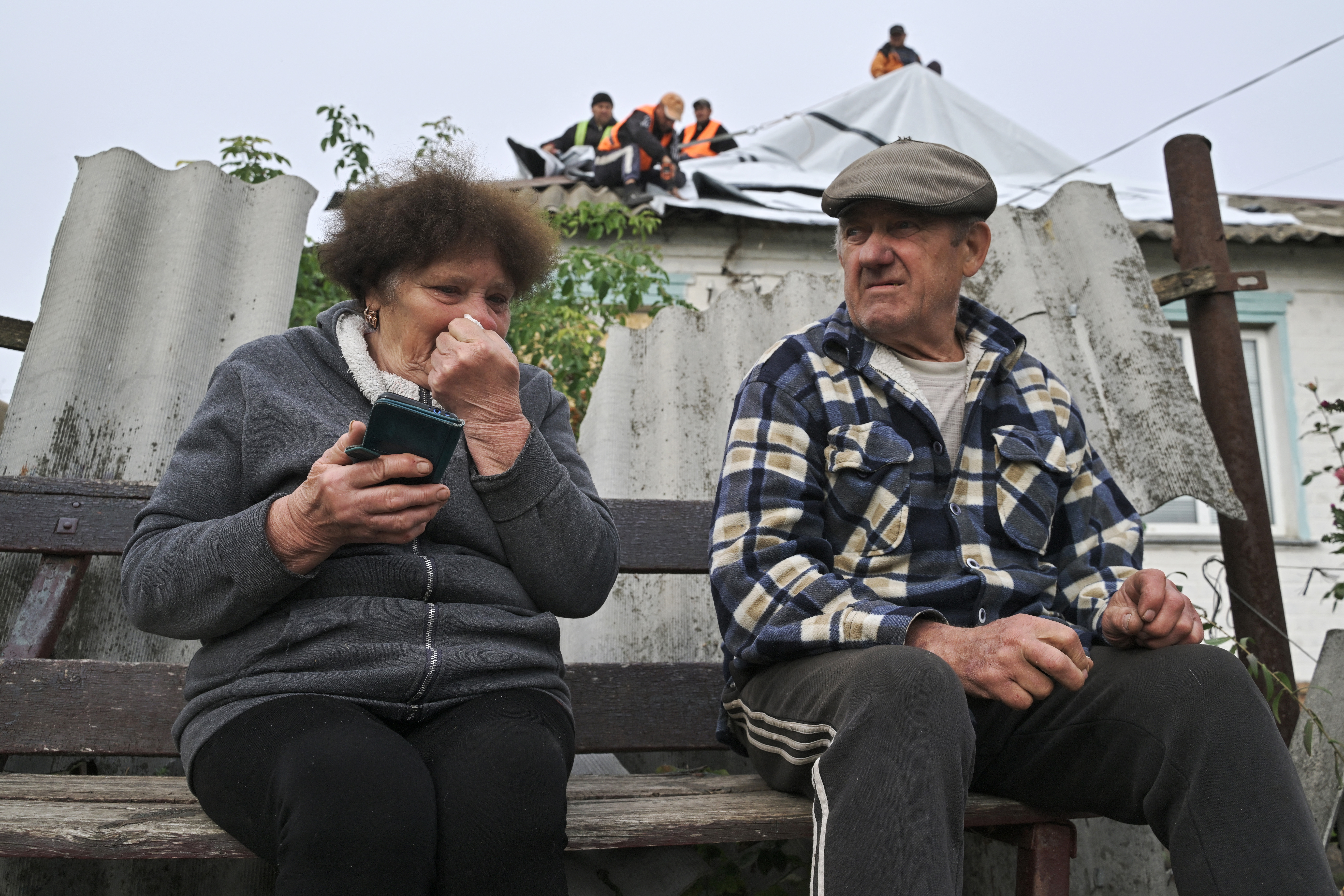 Valentyna, de 73 años, junto a su esposo Volodymyr, de 76, están sentados frente a su casa, afectada tras el ataque ruso en Groza, región de Járkov (este de Ucrania).