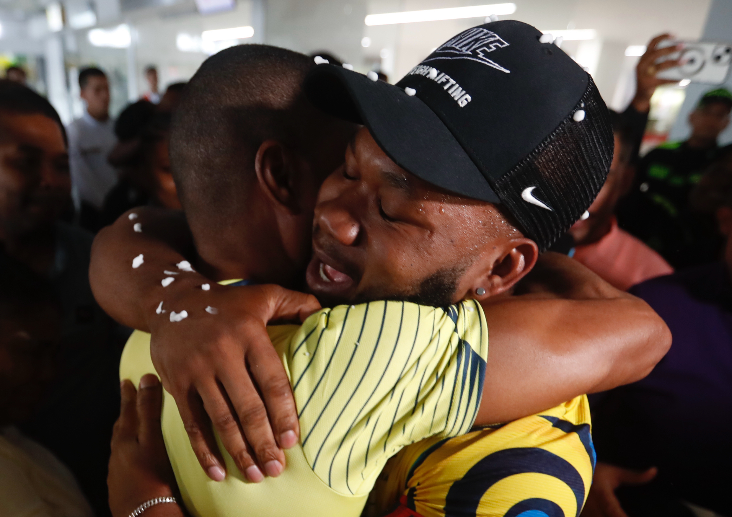 AME9921. CALI (COLOMBIA), 12/08/2024.- El pesista colombiano Yeison López (d), medalla de plata en halterofilia masculina 89kg en Paris 2024, abraza a un familiar este lunes, a su llegada a Cali (Colombia). López y Tatiana Rentería, medallistas olímpicos en París 2024, llegaron al departamento del Valle del Cauca, en el suroeste de Colombia, con una sonrisa indescriptible que solo puede dar la gloria de subirse al podio y entre los aplausos de los colombianos, orgullosos de sus logros. EFE/ Ernesto Guzmán Jr.