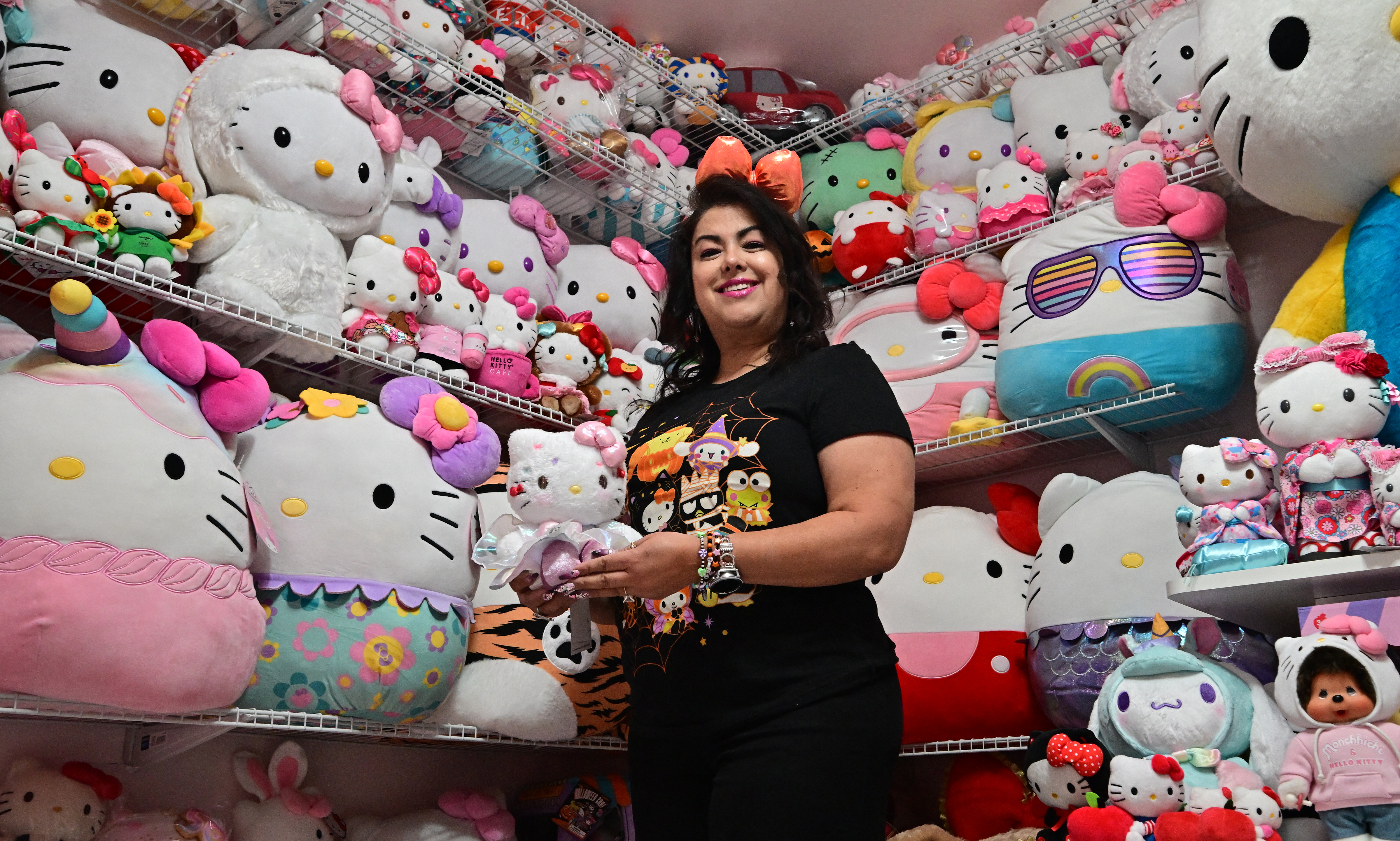 In this picture taken on October 19, 2024, Helen, founder of the 'Hello Kitty SoCal Babes' fan club, poses with her collection inside her "she-shed" in Riverside County, California.