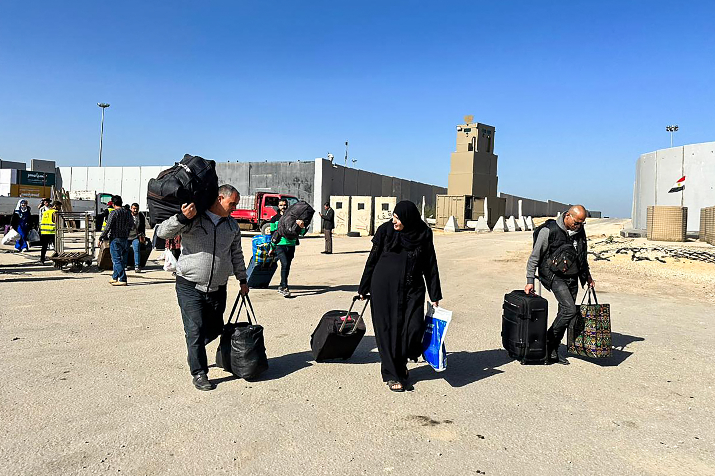 Los pasajeros que regresan a la Franja de Gaza llegan al lado egipcio del cruce fronterizo de Rafah, en la provincia nororiental de Sinaí, horas después del inicio de una tregua de cuatro días.