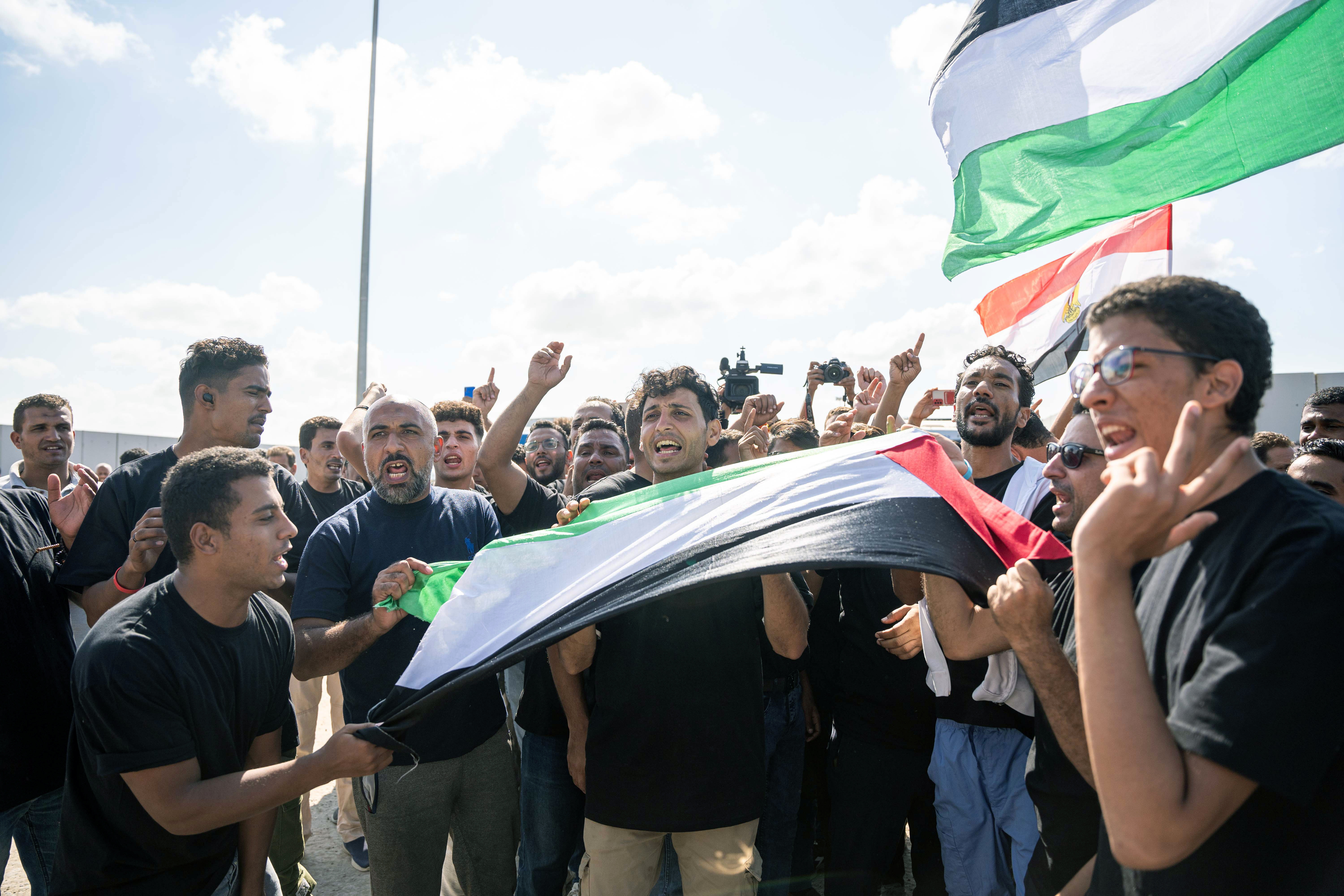 Rafah (Egypt), 18/10/2023.- Volunteers from humanitarian aid organizations chant slogans during a protest outside Rafah border gate, Egypt, 18 October 2023. Volunteers from humanitarian aid organizations staged a sit-in in front of the Rafah border gate, hours after Egypt's President Abdel Fattah al-Sisi blamed Israel for not allowing humanitarian aid into the Gaza Strip and accused Israel of attempting to relocate Palestinians into Sinai. As international mediators continue to push for the passage of aid into Gaza and the exit of foreign nationals fleeing the conflict, from it. Egypt's border crossing with the Gaza Strip in Rafah remained closed on 18 October, with the international aid convoys mostly stationed in the town of Arish some 50km away from Rafah. (Protestas, Egipto) EFE/EPA/ALI MOUSTAFA