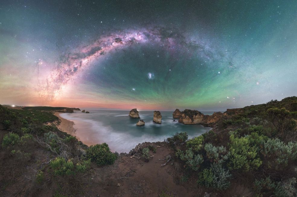 “Galaxia del Conjunto de Piedras” de Alvin Wu. Describe la imagen así: "la Vía Láctea se derrama sobre el mar como una cascada desde el cielo, entrelazándose con el resplandor atmosférico de la superficie del agua".
