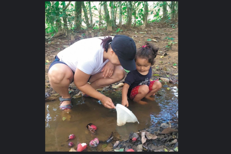 Irina Morales, docente de la U. Pedagógica y PhD en entomología, con su hija en trabajo de campo.