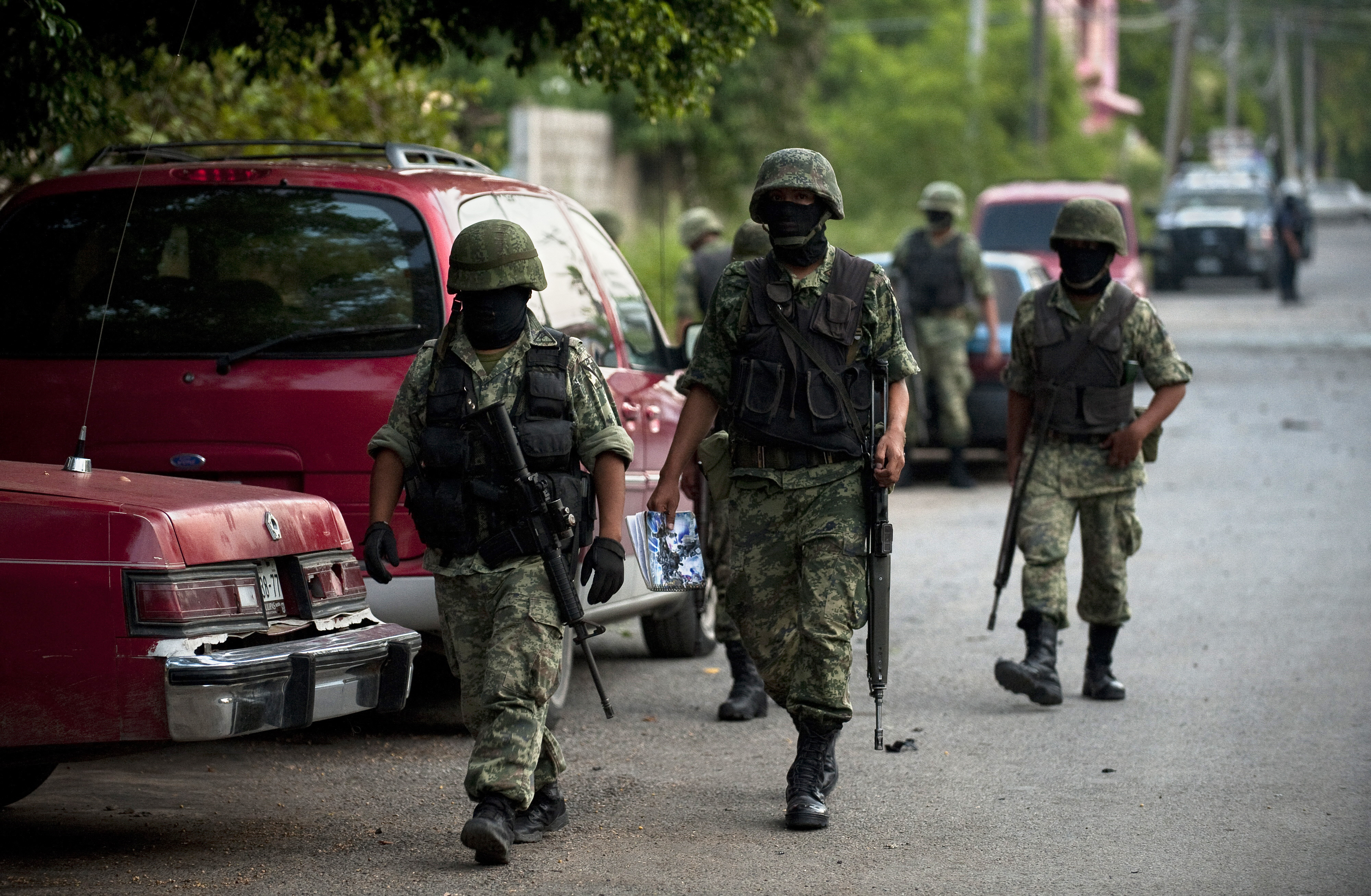 (FILES) Mexican masked soldiers are displayed nearby Televisa TV network after a car bomb exploded with no casualties, early Friday in the northeastern city Ciudad Victoria, Tamaulipas state on August 27, 2010. The Gulf of Mexico drug cartel has been engaged in a bitter turf war for control of Tamaulipas smuggling routes into the United States with the Zetas drug cartel. AFP PHOTO/Ronaldo Schemidt