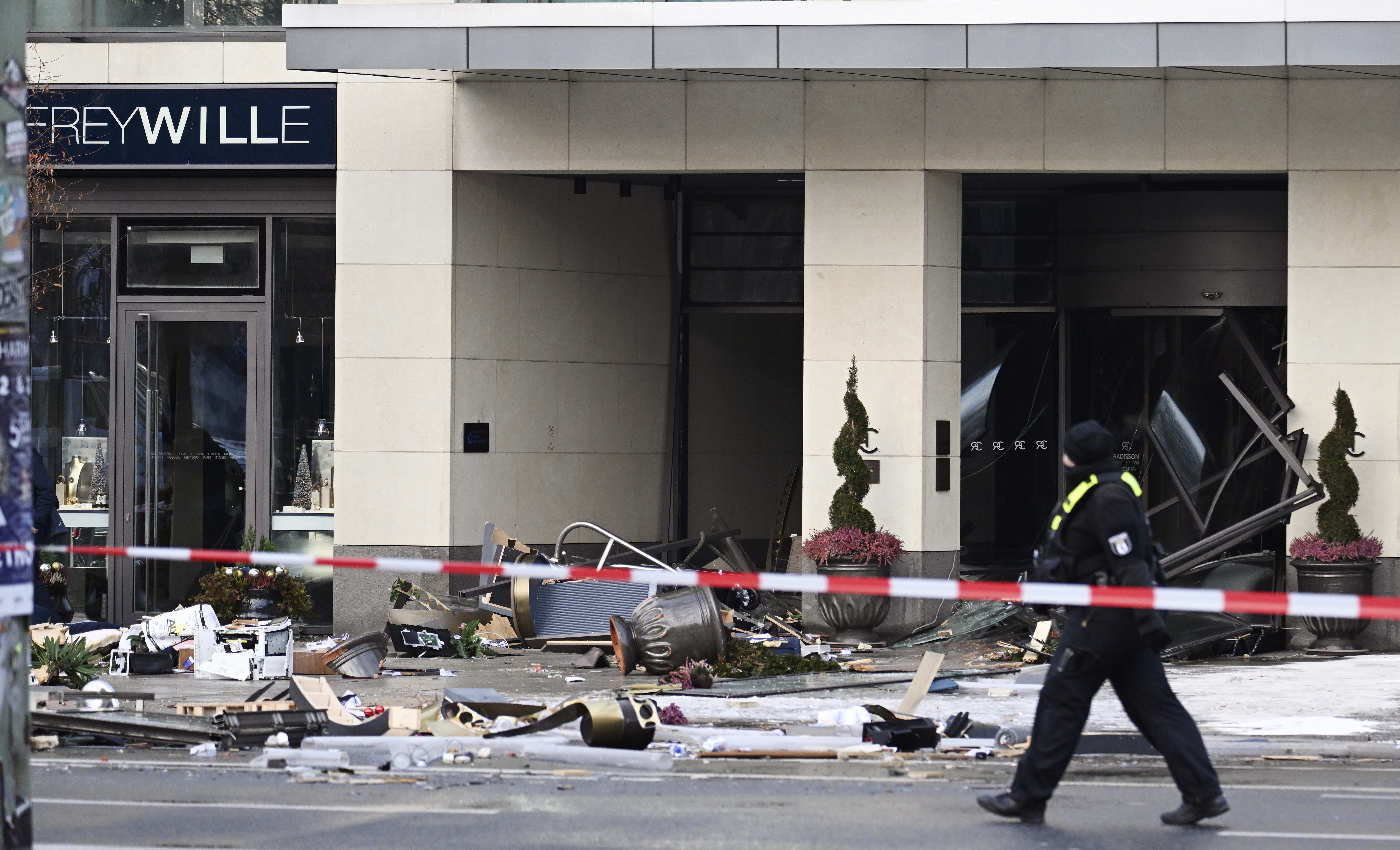 Berlin (Germany), 16/12/2022.- A police officer passes a hotel after a burst and leak of the AquaDom aquarium in Berlin, Germany, 16 December 2022. A 14-meter aquarium has burst at a hotel in downtown Berlin, injuring two people, German rescue services said. The home to around 1,500 exotic fish spills 1 million liters of water and floats a major road in the Mitte district, emergency services said. (Alemania) EFE/EPA/FILIP SINGER