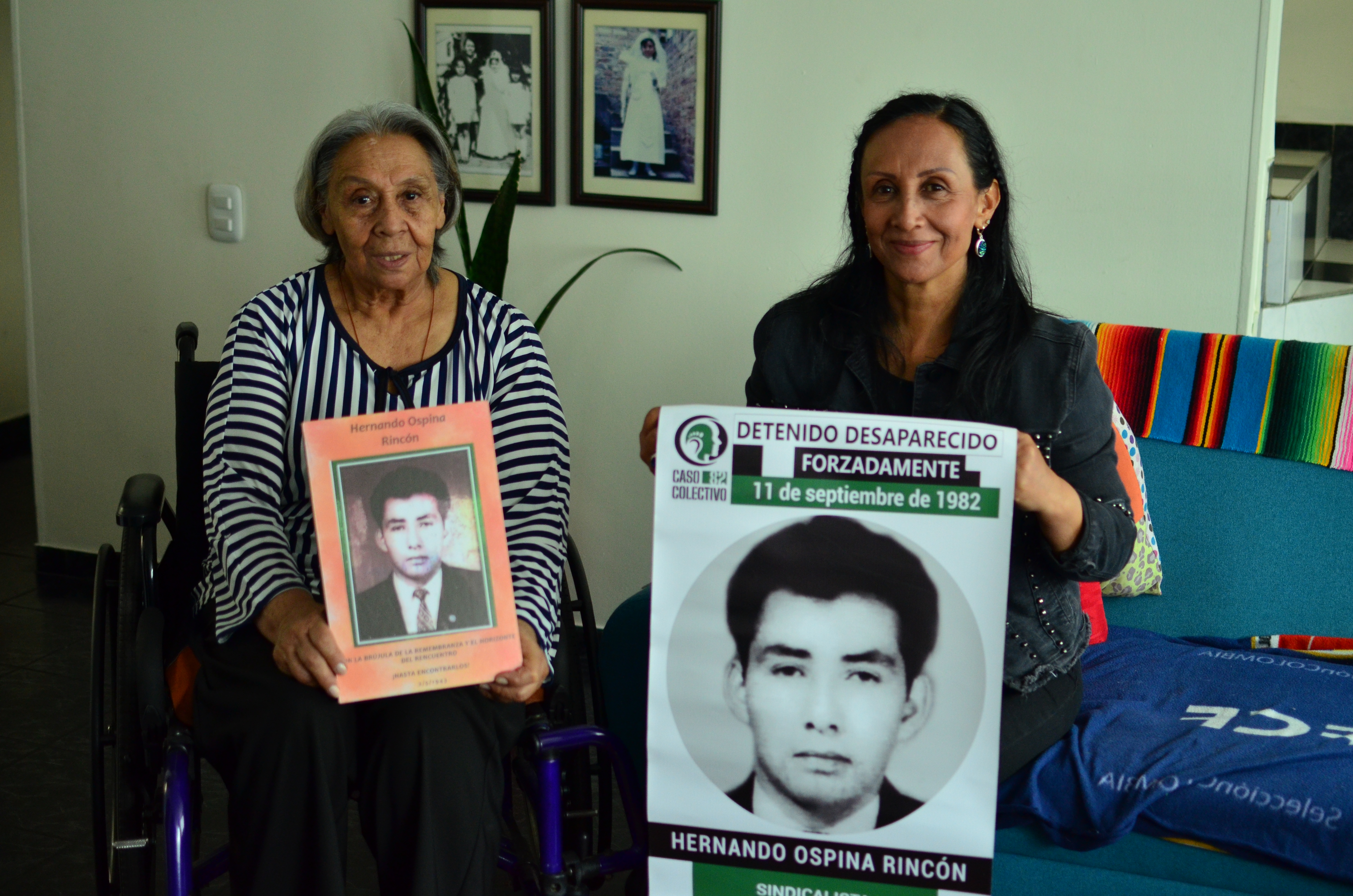 Doña María Elena Ruiz, de 73 años, y su hija, Marta Ospina, de 53, sosteniendo una imagen de Hernando Ospina, esposo y padre respectivamente, quien fue detenido y desaparecido forzadamente en marzo de 1982.
