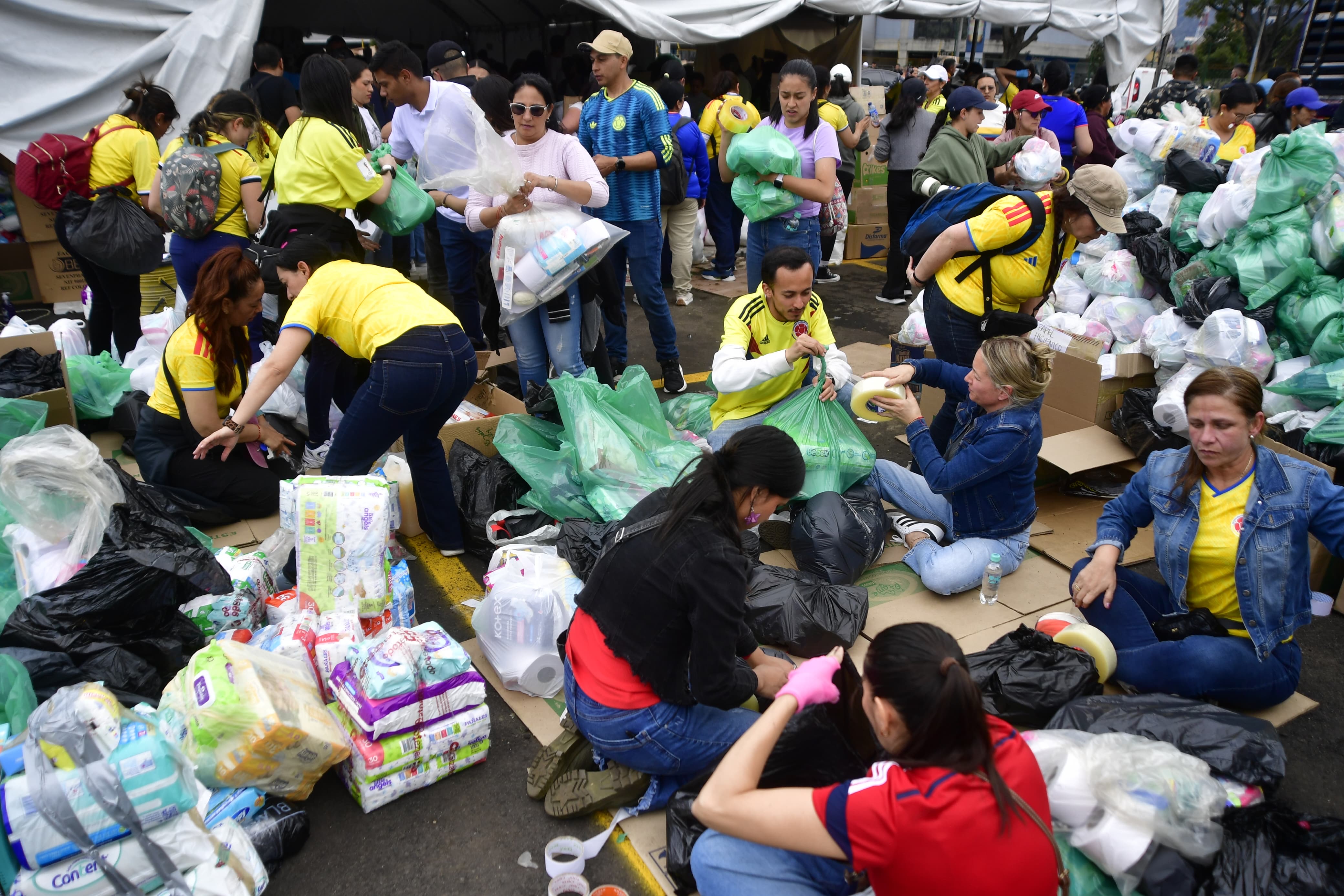 Miles de voluntarios se concentran en los puntos de acopio habilitados en inmediaciones de El Campín, donde organizan, clasifican y empacan las donaciones que han llegado de manera masiva. Entre cadenas humanas y jornadas de apoyo ciudadano, las ayudas son preparadas para su envío en los próximos días, mientras se define su destino de acuerdo con las necesidades de las zonas afectadas y el volumen de elementos recolectados.