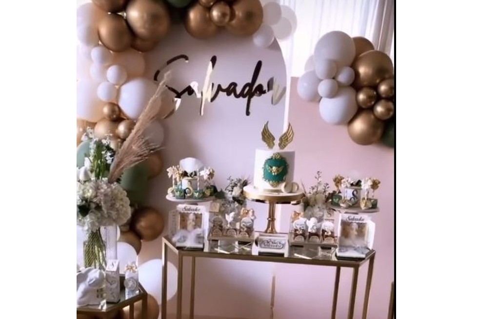 Después de la ceremonia religiosa que se llevó a cabo en una iglesia, Lincoln y Carolina tenían una decoración especial en su apartamento para recibir a sus invitados y festejar el bautizo del pequeño. Con globos blancos, dorados y verdes rodearon el nombre de Salvador que estaba pegado a una pared. Además, hubo un pequeño ponqué y algunos postres decorados con la letra S.
