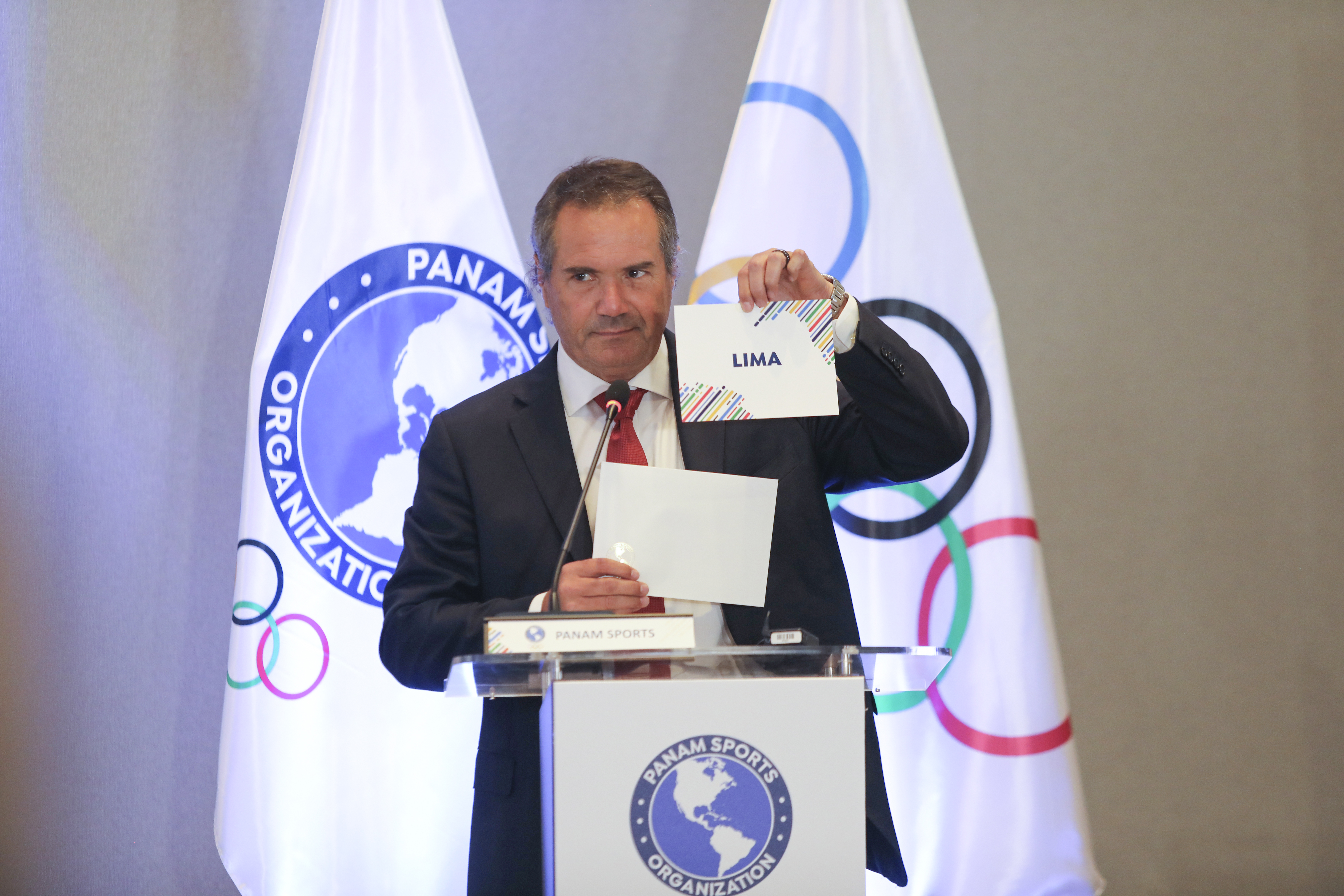 AMDEP7922. MIAMI (ESTADOS UNIDOS), 12/03/2024.- Fotografía cedida por Panam Sports de su presidente, Neven Ilic, sosteniendo el nombre de Lima como ciudad anfitriona de los Juegos Panamericanos 2027 este martes, en una sesión extraordinaria del organismo en Miami (FL. EE.UU.). La capital de Perú ganó la sede de los próximos Juegos Panamericanos con un total de 28 votos, en un proceso de elección realizado en forma remota por los 40 representantes. EFE/ Panam Sports /SOLO USO EDITORIAL/ SOLO DISPONIBLE PARA ILUSTRAR LA NOTICIA QUE ACOMPAÑA (CRÉDITO OBLIGATORIO)
