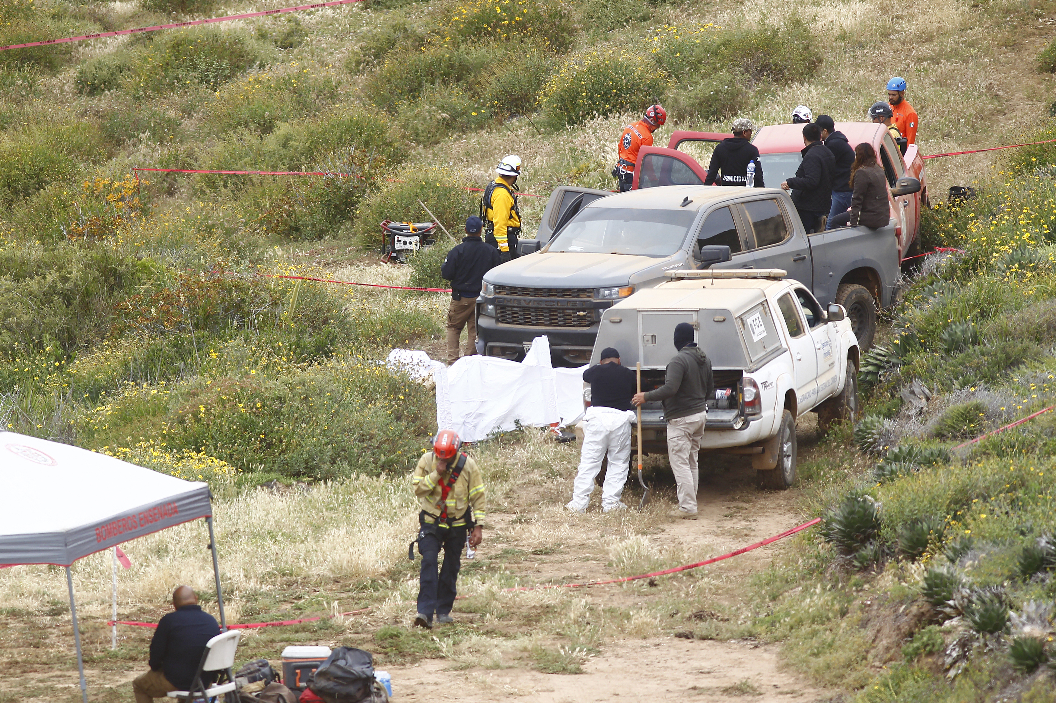 MEX6661. ENSENADA (MÉXICO), 05/05/2024.- Peritos forenses trabajan en la zona donde se localizaron los cuerpos de dos surfistas australianos y un estadounidense este jueves en el poblado Santo Tomas en la ciudad de Ensenada (México). Autoridades mexicanas señalaron este domingo que el probable homicidio de los tres surfistas extranjeros en Baja California, noroeste de México, fue por el robo de un vehículo en el que viajaban y no por su calidad de “turistas”. EFE/Alejandro Zepeda
