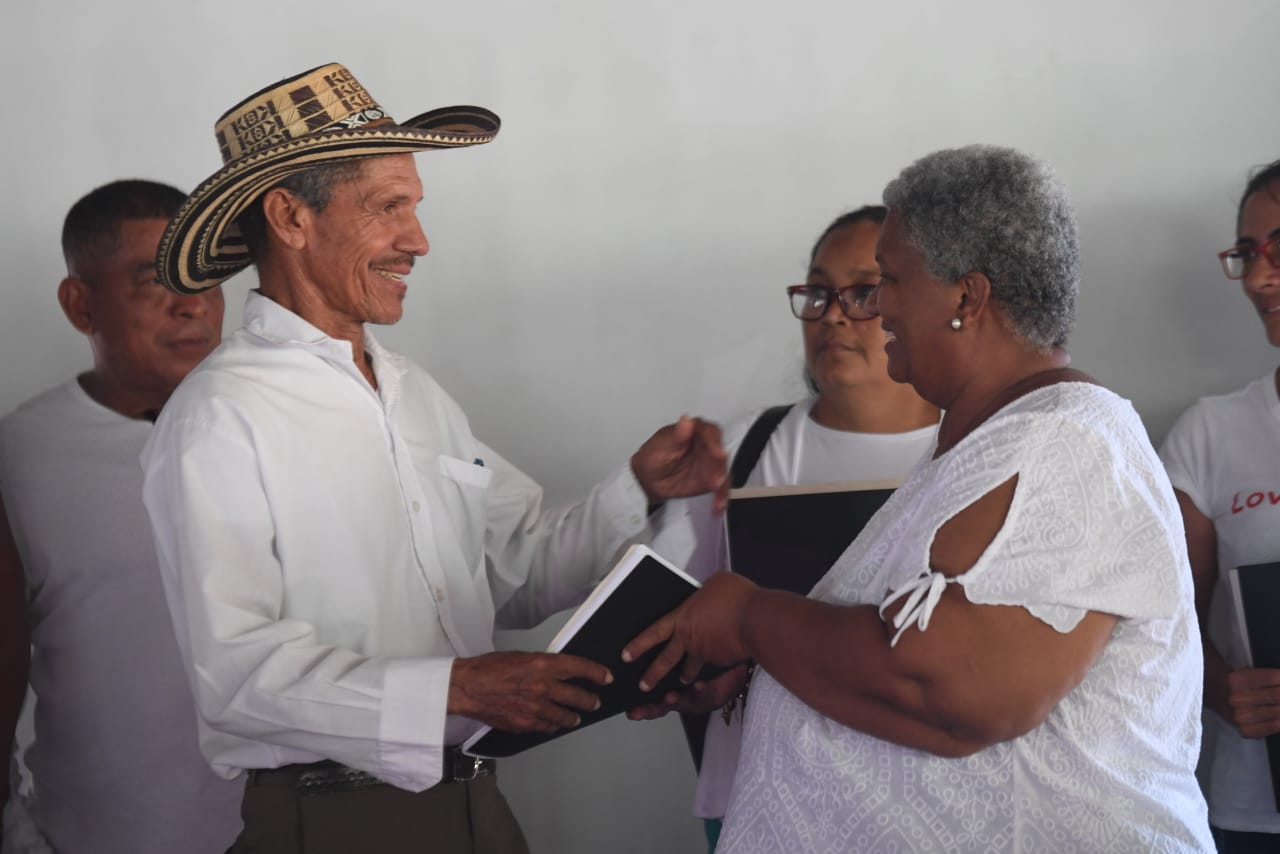 Pie de foto: Angela Salazar, la comisionada de la Verdad, recibe de un campesino víctima uno de los informes.