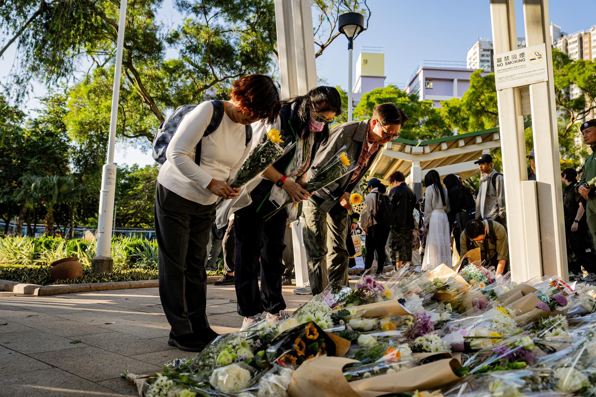 HONG KONG (China), 29/11/2025.- People lay floral tributes for the victims of the fire at the Wang Fuk Court residential estate in the Tai Po district of Hong Kong, China, 29 November 2025. The city is mourning 128 people killed in the high-rise apartment fire, with about 200 others still unaccounted for. EFE/EPA/LEUNG MAN HEI