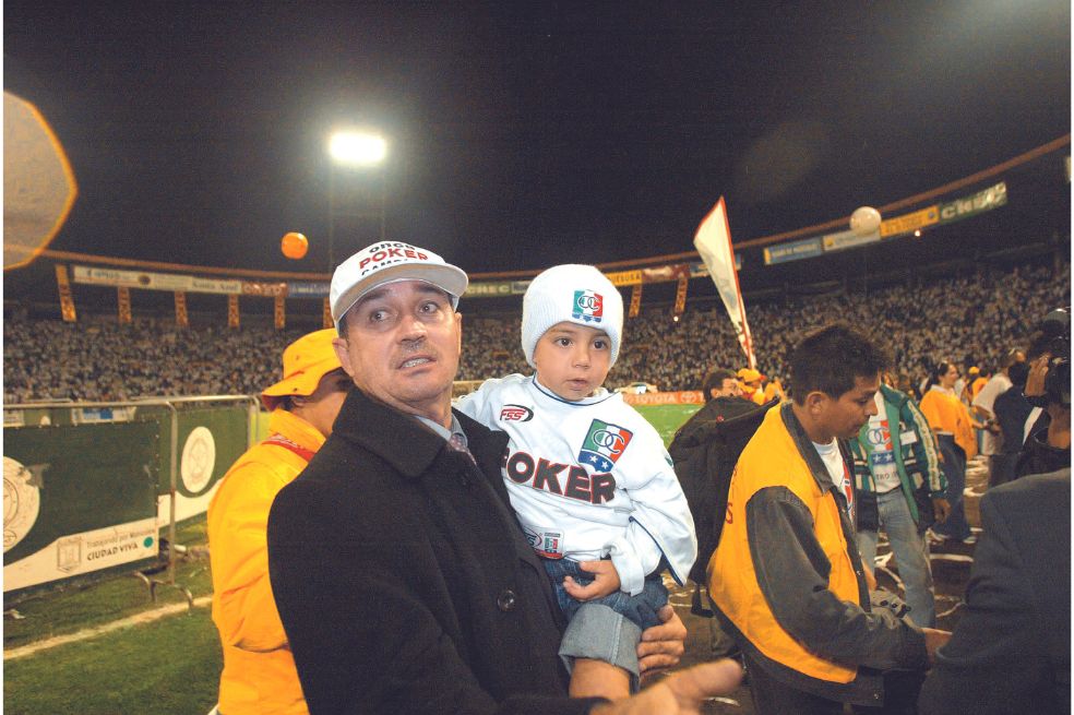 Luis Fernando Montoya carga a su hijo en el Estadio de Palogrande, tras el campeonato de Once Caldas en la Copa Libertadores.