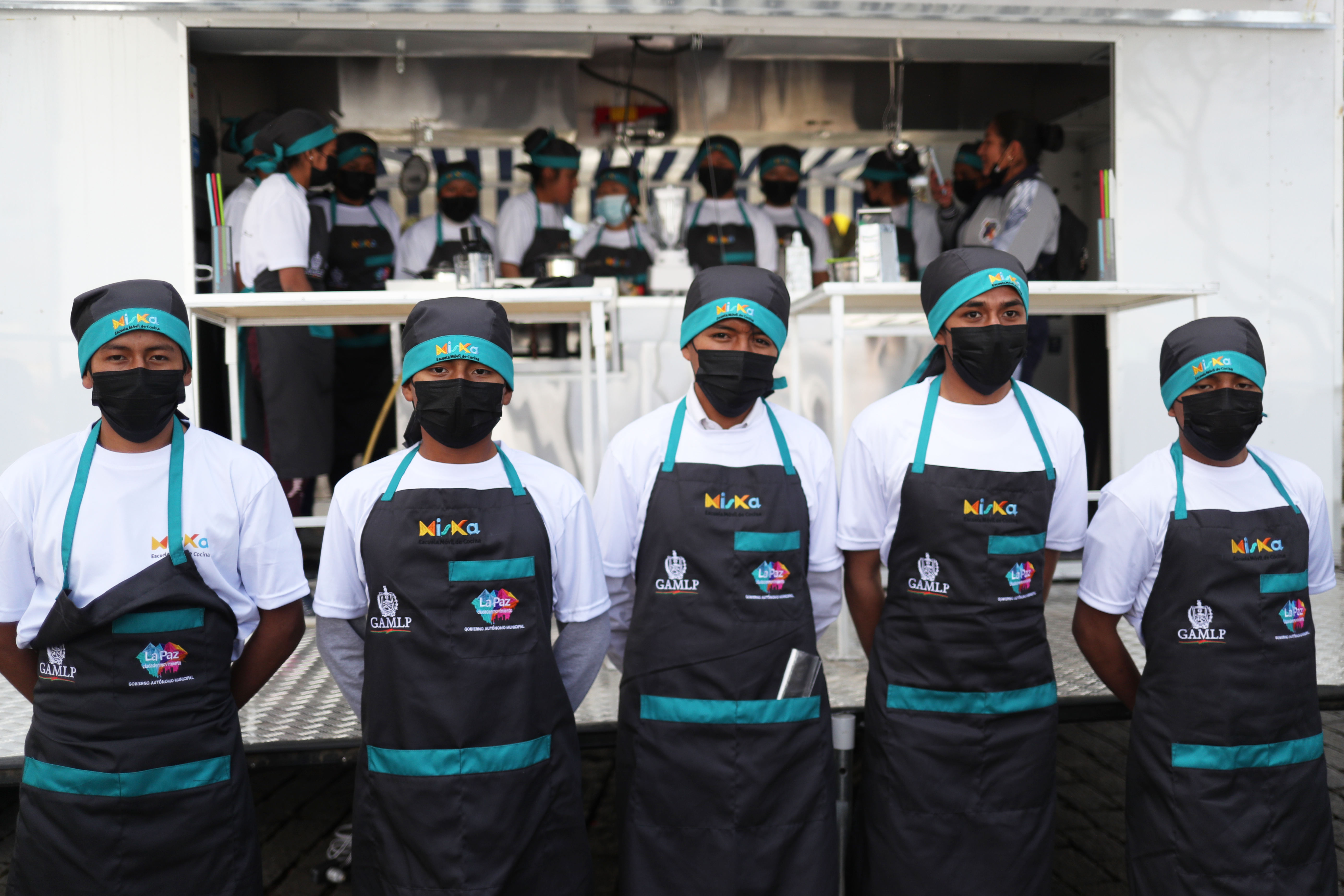 AME8940. LA PAZ (BOLIVIA), 12/05/2023.- Estudiantes de gastronomía posan delante la escuela móvil de cocina "Miska", hoy, en La Paz (Bolivia). Una formación en gastronomía que no tiene nada que envidiar a la ofrecida en las áreas urbanas llegará a las zonas rurales de Bolivia a través de "Miska", las escuelas móviles montadas en pequeños camiones con las que también se buscará revalorizar las recetas y productos locales. EFE/ Luis Gandarillas