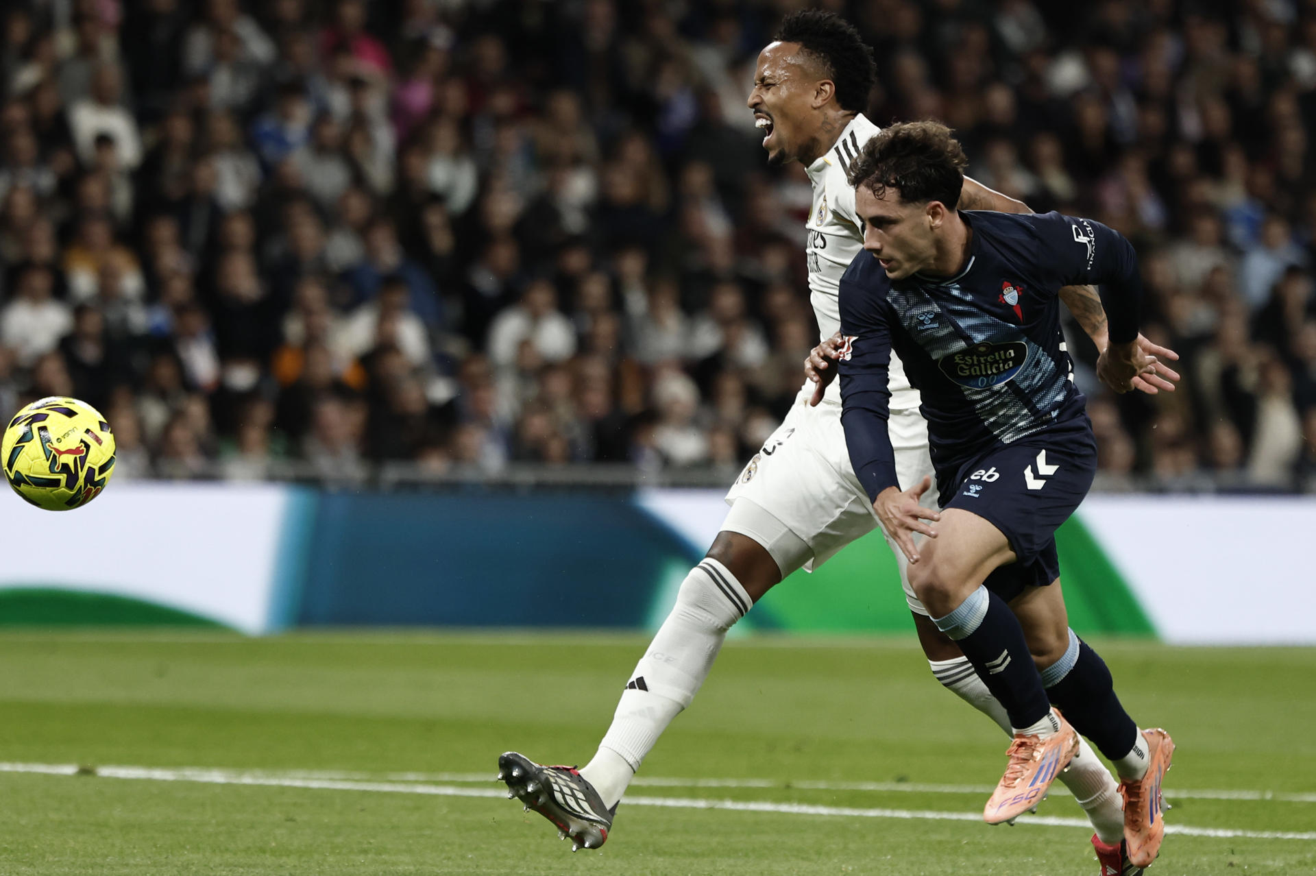 MADRID, 07/12/2025.- El defensa del Real Madrid Éder Militao (i) pelea un balón con Pablo Durán, del Celta, durante el partido de LaLiga de fútbol que Real Madrid y Celta de Vigo disputan este domingo en el estadio Santiago Bernabéu. EFE/Sergio Pérez