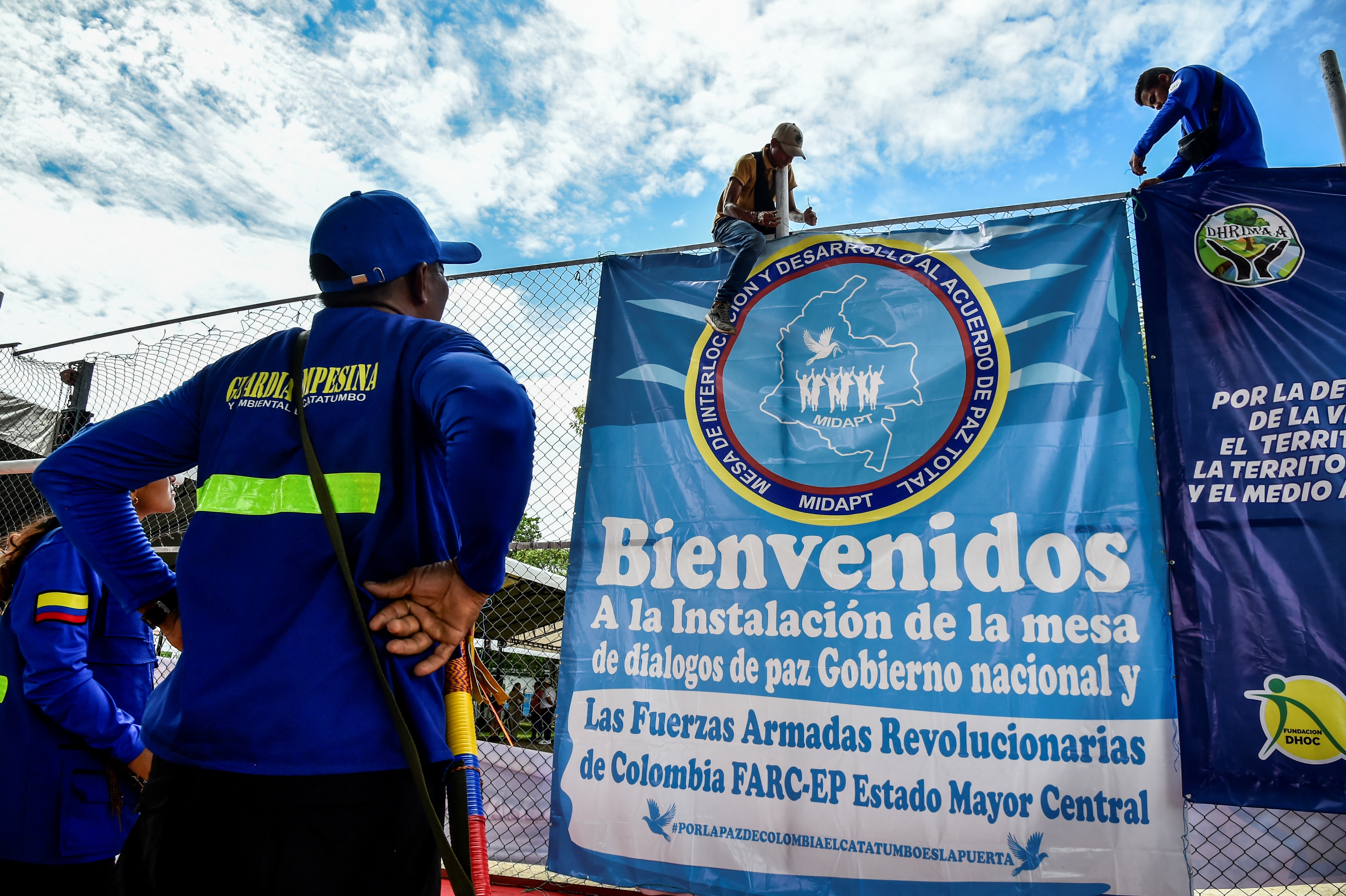 Miembros de la guardia indígena cuelgan un pendón a la entrada del polideportivo de Tibú, Norte de Santander, donde este domingo 8 de octubre se tiene prevista la instalación de la mesa de diálogo con la disidencia de FARC, autodenominada Estado Mayor Central