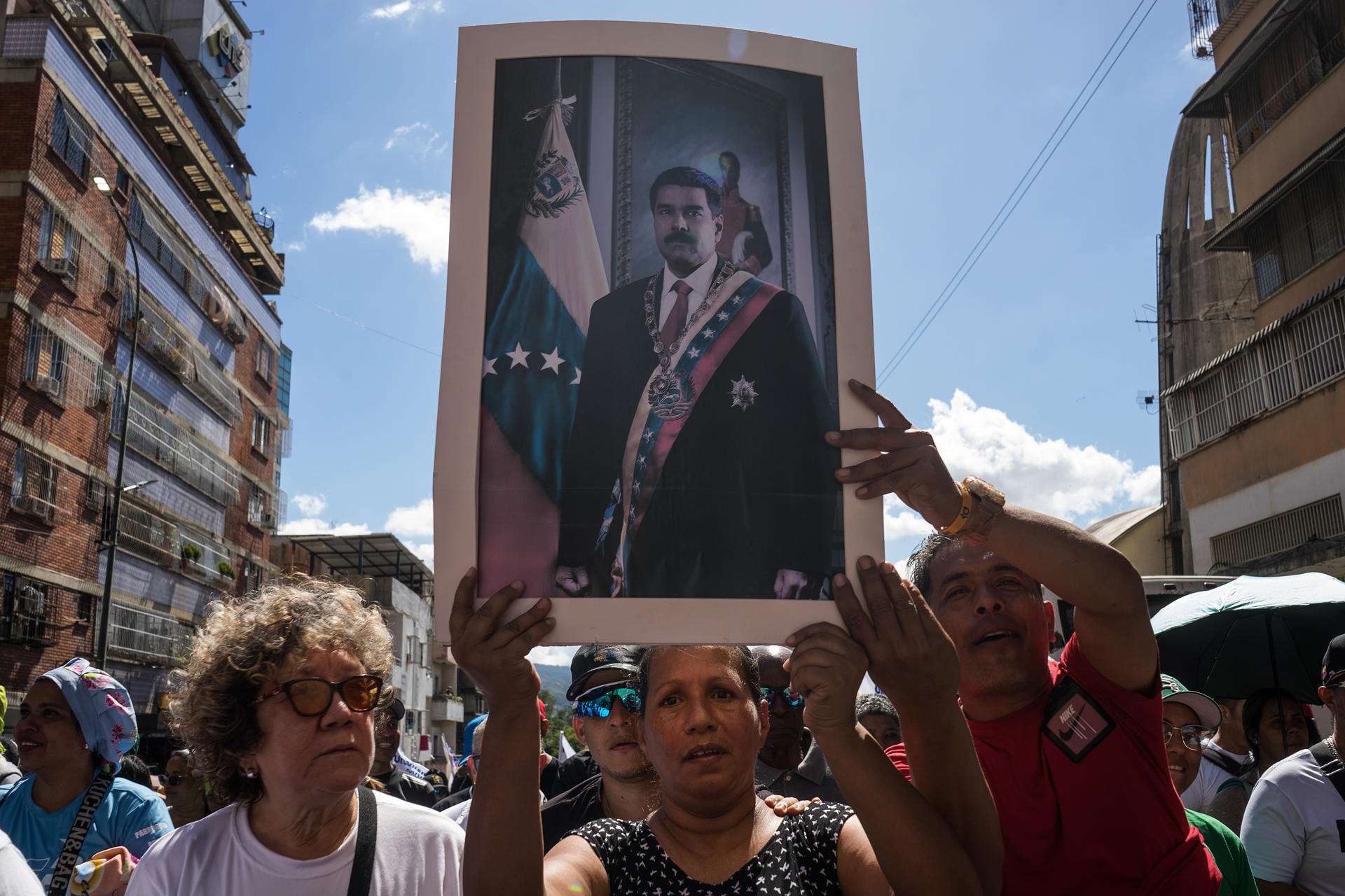 FOTODELDÍA AME3656. CARACAS (VENEZUELA), 09/01/2026.- Personas sostienen un afiche con la imagen del presidente de Venezuela, Nicolás Maduro, durante una manifestación este viernes, en Caracas (Venezuela). Miles de chavistas regresaron a las calles de Caracas para exigir la liberación de Nicolás Maduro y su esposa, Cilia Flores, quienes fueron capturados el pasado sábado por fuerzas estadounidenses durante el ataque militar en el país suramericano. EFE/ Boris Vergara