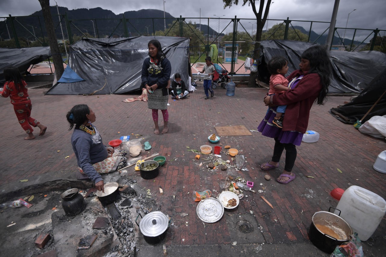 Tres mujeres indígenas cocinan en la calle.