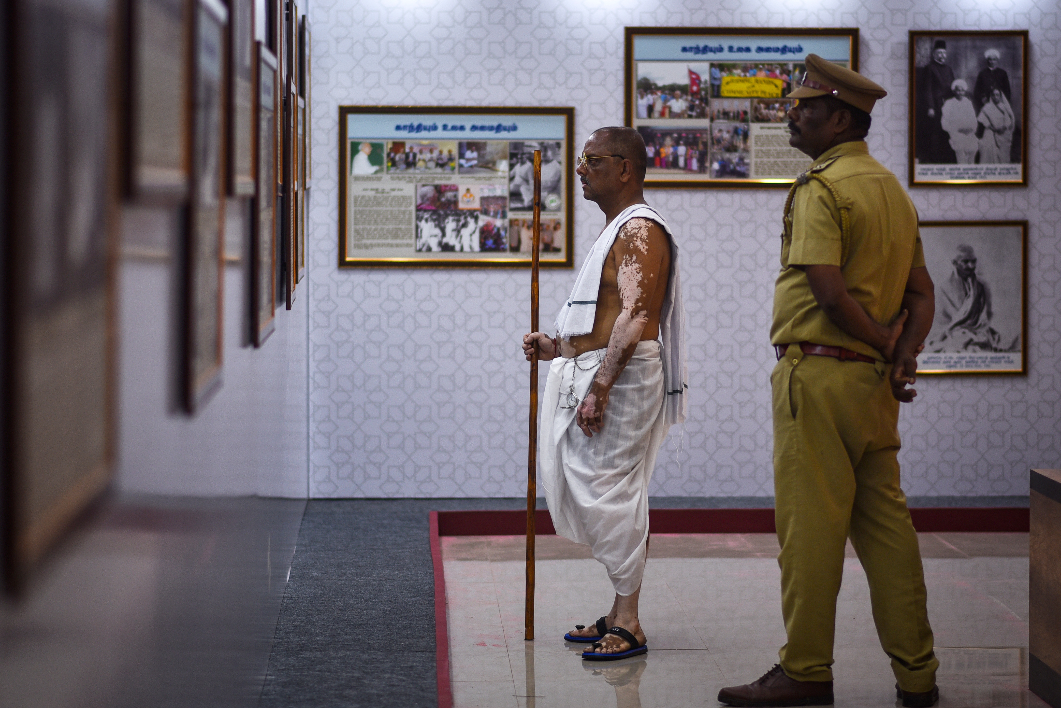 Chennai (India), 30/01/2023.- Anand Kumar Bhowmick, 57, dressed up as Mahatma Gandhi looks at pictures of Gandhi on the occasion of Martyr's Day, marking his 75th death anniversary, at Egmore Museum in Chennai, India 30 January 2023. Martyr's Day is observed annually on 30 January in India to commemorate the death of the father of the nation, Mahatma Gandhi, who was assassinated by Nathuram Vinayak Godse on 30 January 1948. The day is observed as a day of peace and non-violence. EFE/EPA/IDREES MOHAMMED