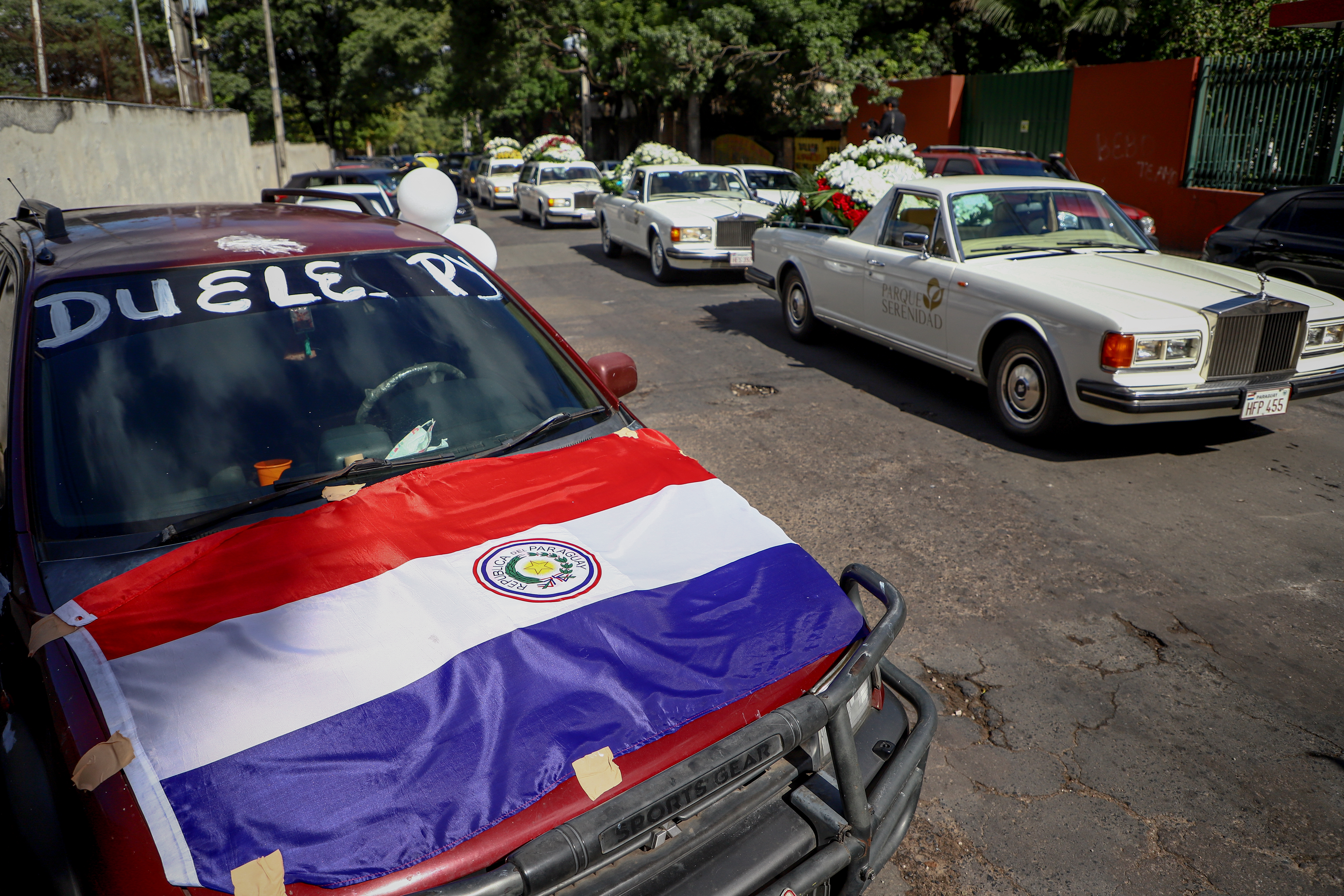 AME9535. ASUNCIÓN (PARAGUAY), 15/05/2022.- El carro fúnebre que transporta los restos del asesinado fiscal Marcelo Pecci llega hoy a la sede del Club Guaraní en Asunción (Paraguay). Marcelo Pecci, el fiscal asesinado en Colombia y a quien este domingo despiden los paraguayos, se erigió públicamente en implacable contra el delito, pero para sus allegados era el hombre de buen humor, apasionado por el fútbol y la aviación. Asimismo, dirigentes, futbolistas y fanáticos del Club Guaraní le rinden un homenaje al fiscal Pecci en la sede del club. EFE/ Nathalia Aguilar
