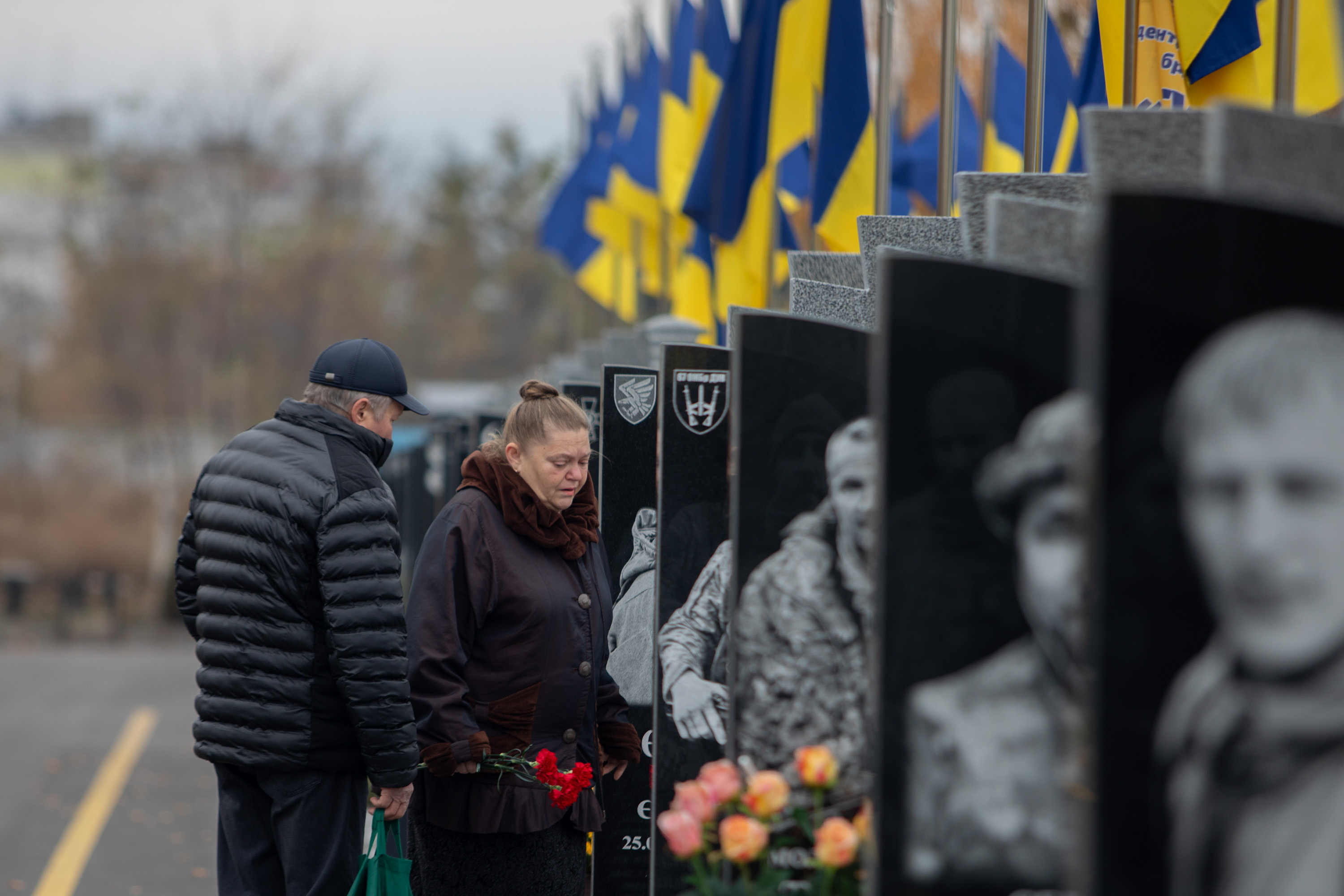 Padres de familia visitan la tumba de su hijo caído en combate en el cementerio de Cherkasy.