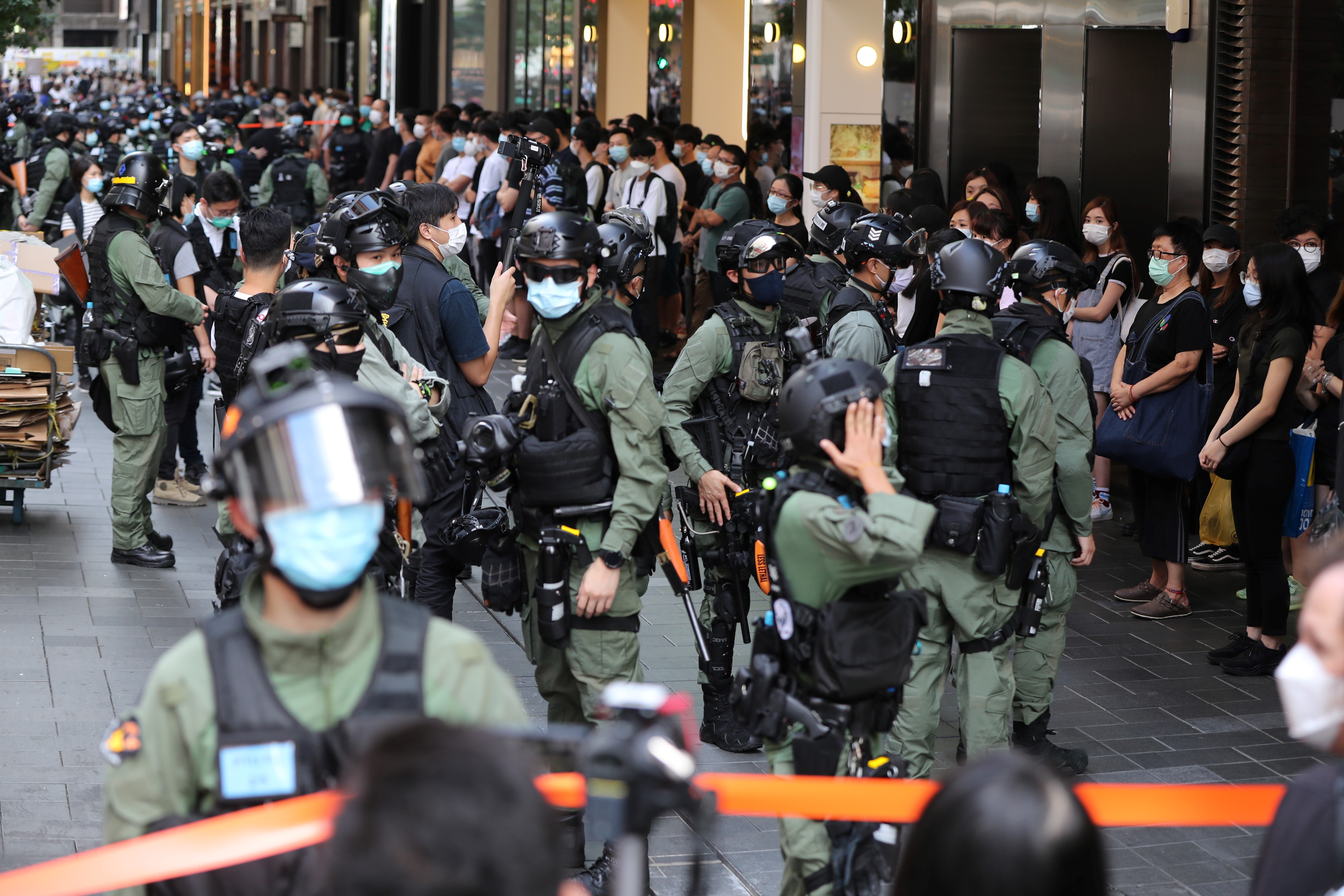 Los agentes de policía se preparan para registrar a las personas dentro de un área acordonada durante el Día Nacional de China en Hong Kong el 1 de octubre de 2020, que conmemora el 71 aniversario del establecimiento de la República Popular China.