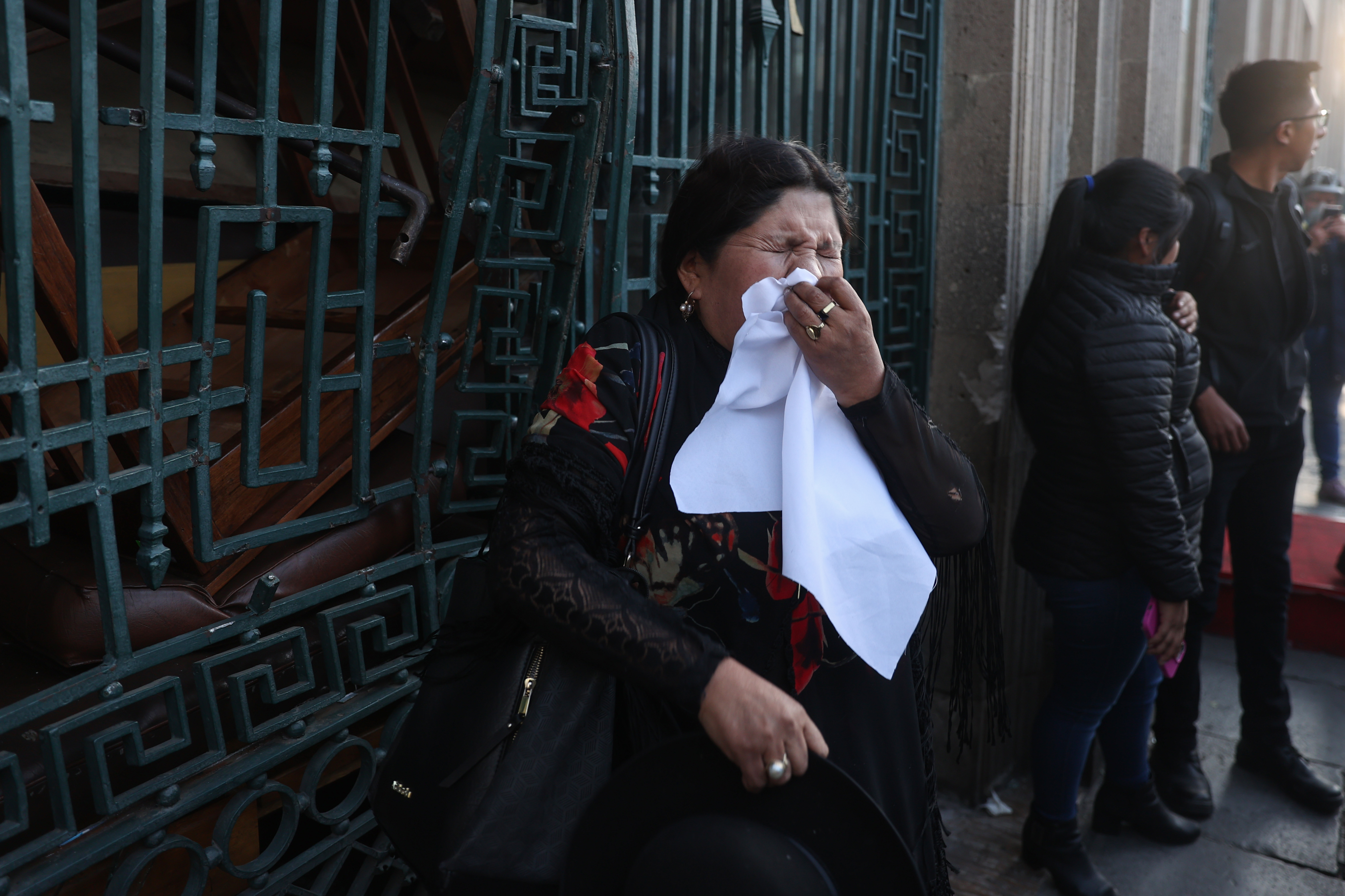 AME6897. LA PAZ (BOLIVIA), 26/06/2024.- Una mujer se protege de gases durante un movimiento militar frente a la sede del Gobierno de Bolivia, este miércoles en La Paz (Bolivia). El presidente de Bolivia, Luis Arce, denunció un "golpe de Estado" por parte del ahora destituido comandante general del Ejército boliviano Juan José Zuñiga, quien fue relevado este miércoles junto a los demás mandos militares, señaló que "resistirá" y llamó a "movilizaciones" para defender la democracia. EFE/ Luis Gandarillas