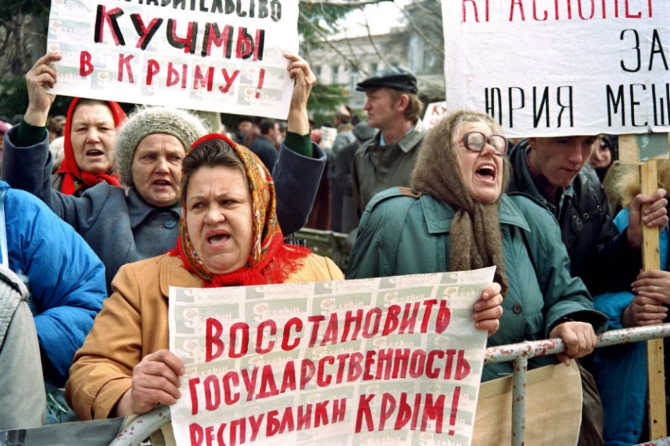 Mujeres rusas sostienen pancartas y gritan delante del Parlamento de Crimea en Simferopol.